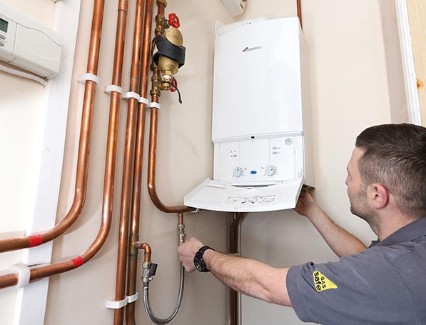 Engineer repairing a broken boiler during a heating system breakdown