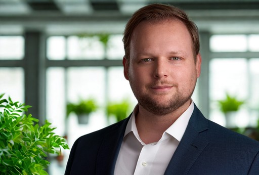 ceo and founder of prolodge in a studio photoshoot headhot standing in a clean modern office with green plants in the background