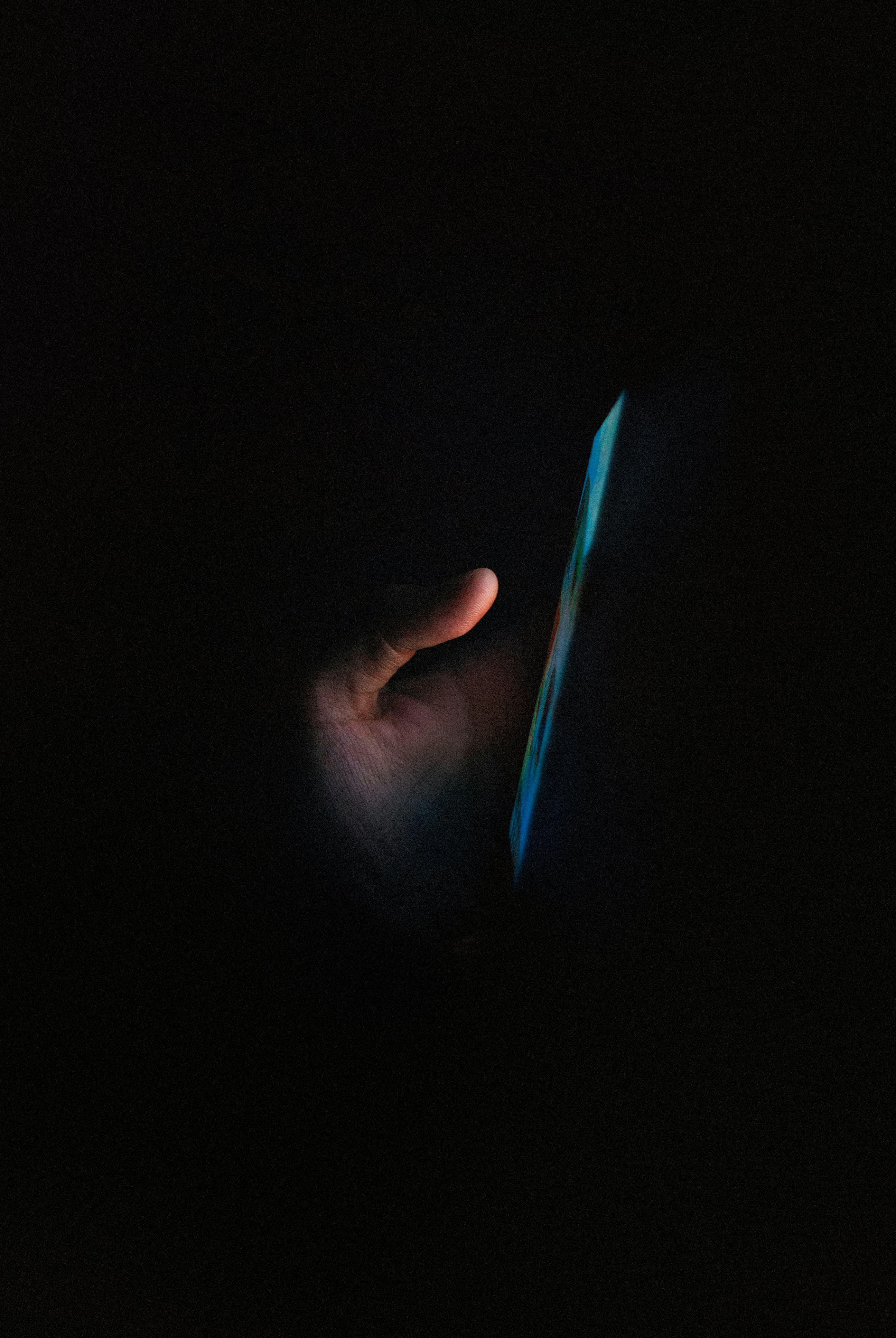 person holding blue light in dark room