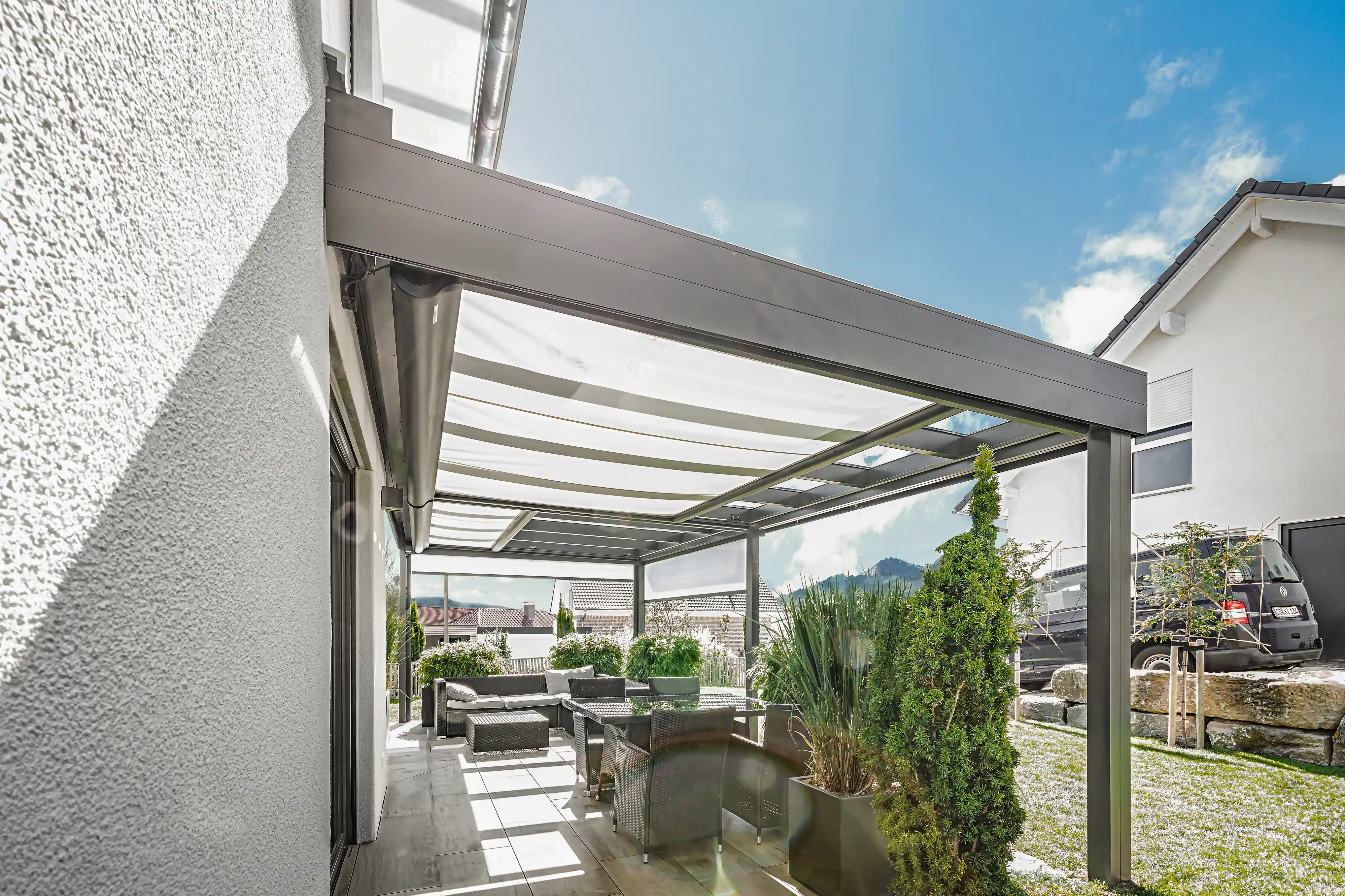 Seitliche Aufnahme kubische Terrassenüberdachung mit Sonnereflexion und outdoor lounge