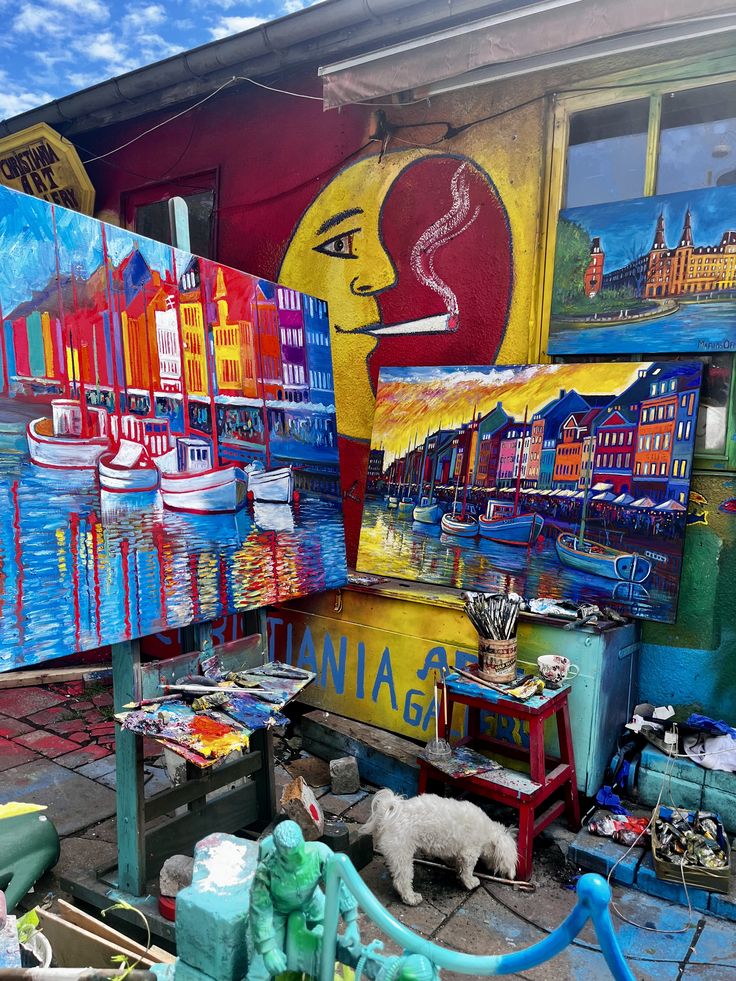 a building covered in lots of graffiti next to a tree