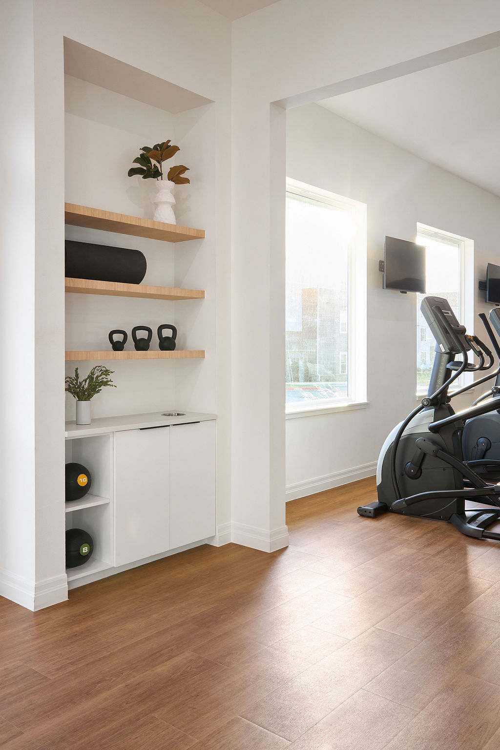 Primary bedroom cabinet, chair and view into bathroom