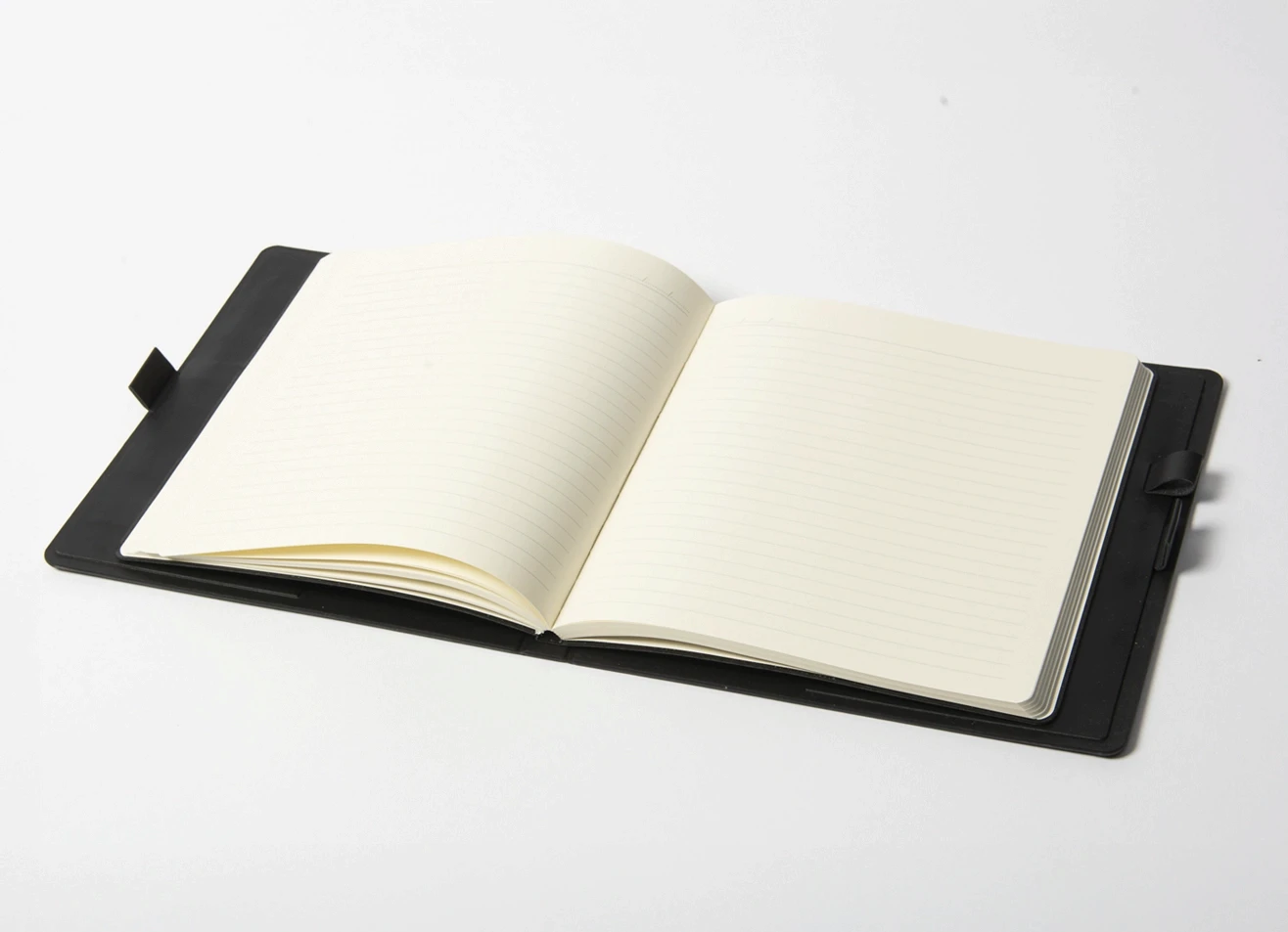 Open notebook showing lined pages and pen loop.