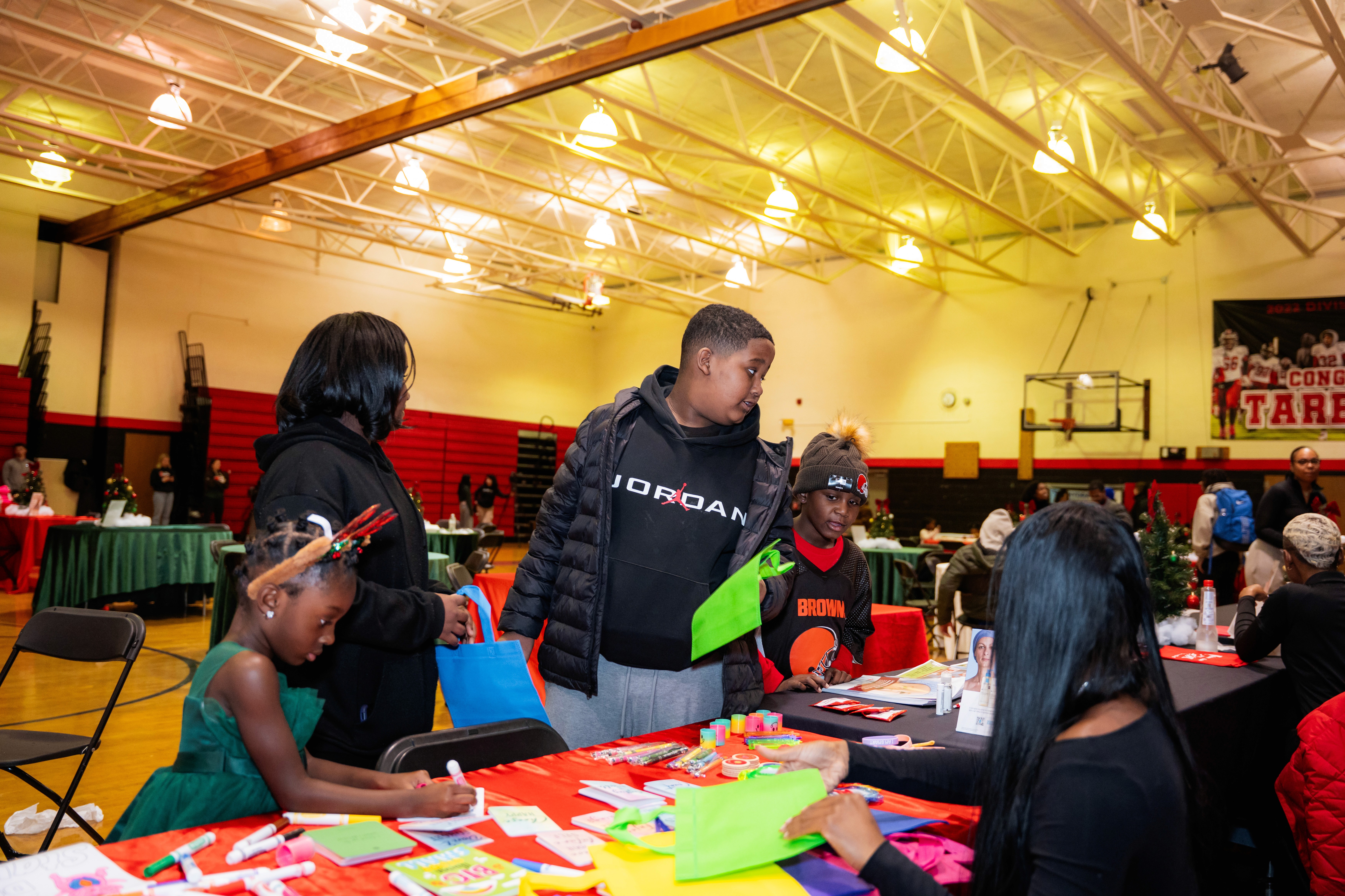 person in gray hoodie holding red and white box