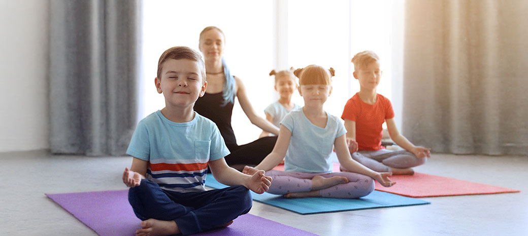 Students practicing guided meditation and breathing techniques in school-based mindfulness enrichment program