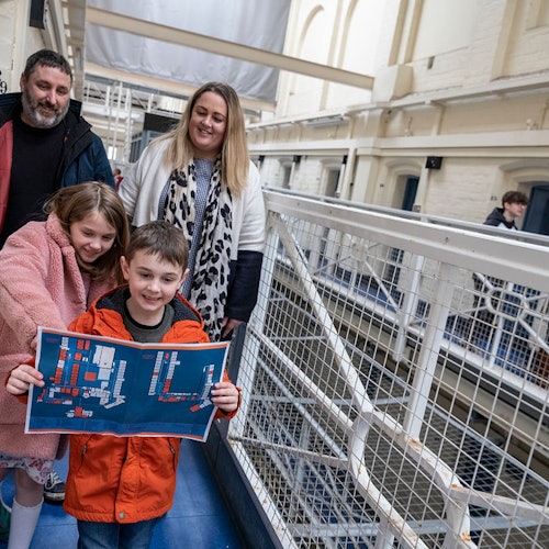 一群游客手持地图探索什鲁斯伯里监狱。