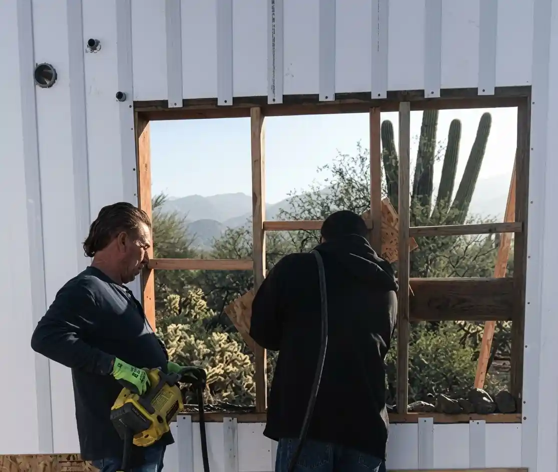 Two men installing a window well in an ICF wall in Arizona
