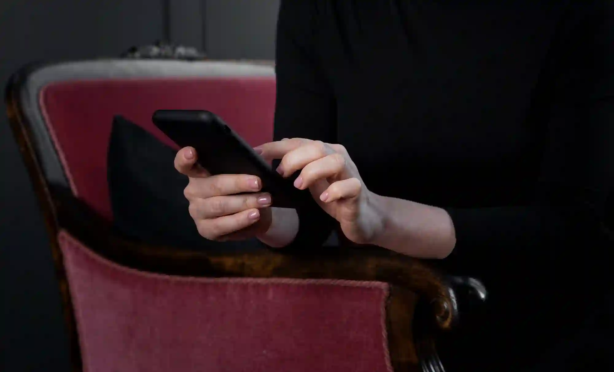 Close-up of a person using a smartphone to integrate digital solutions while seated in a professional indoor setting.