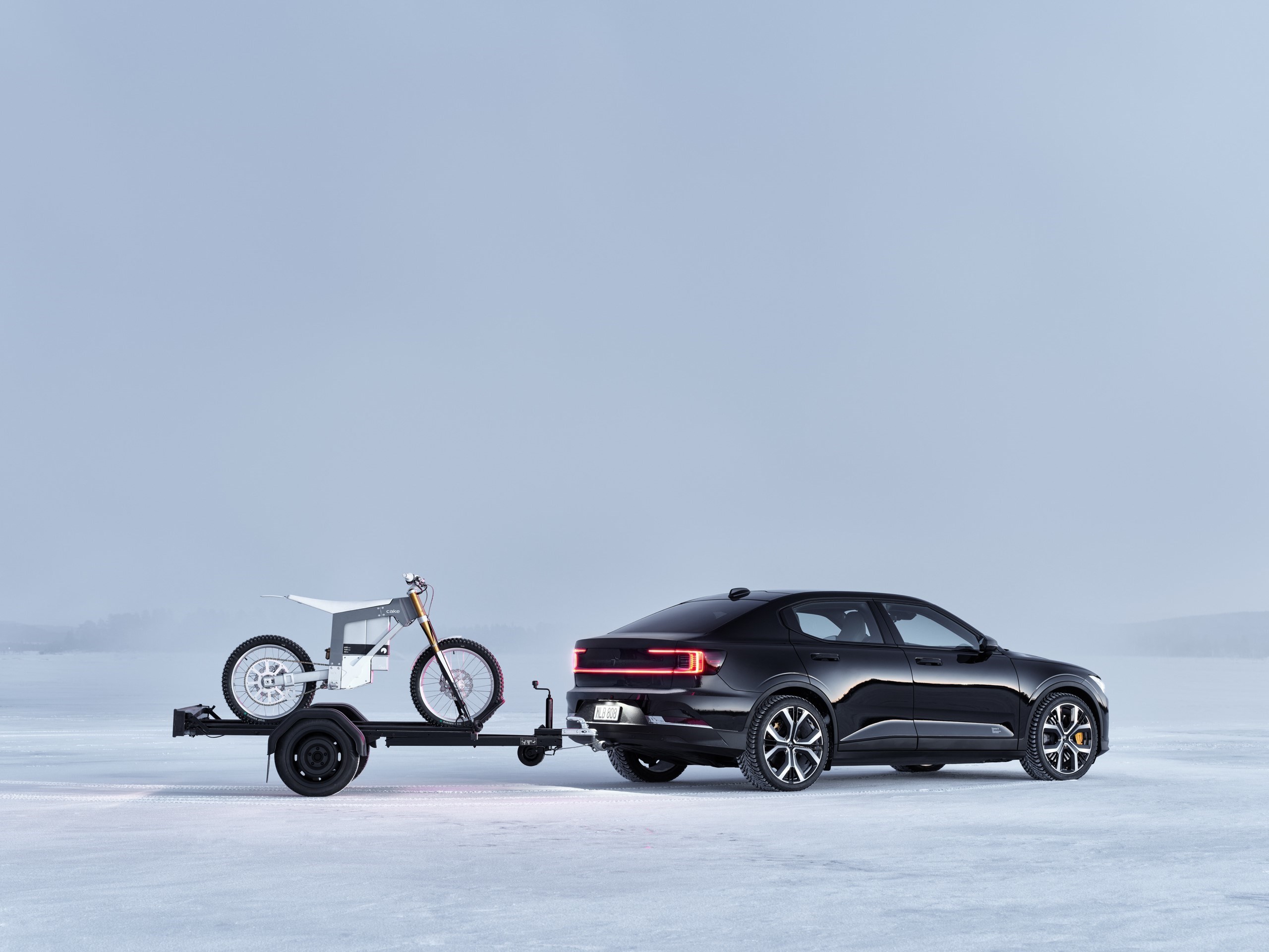 Polestar 2 avec attelage qui tracte une remorque avec une moto