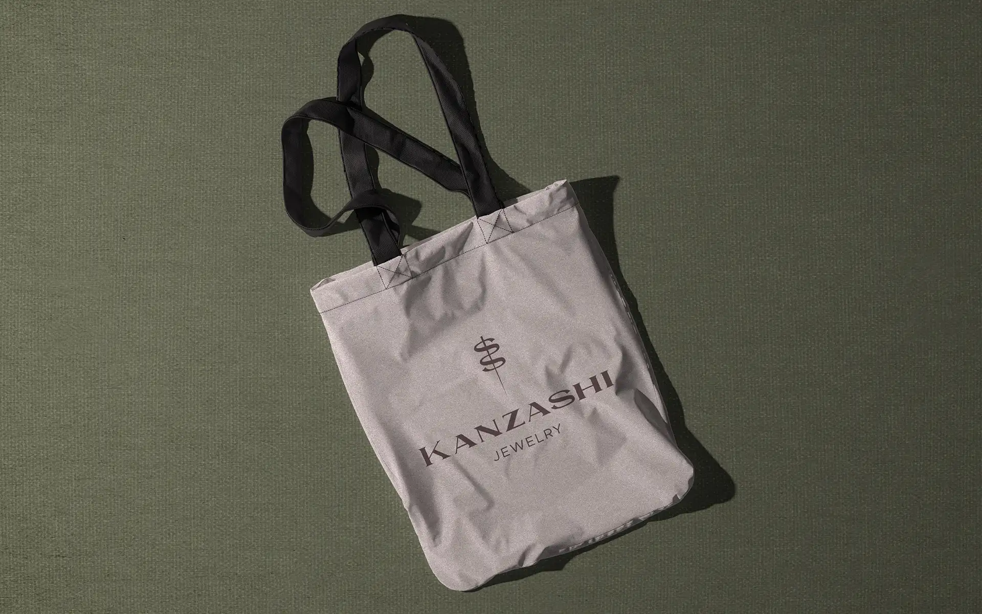 Brand collateral design for Kanzashi jewelry brand showing logo and logomark applied to branded tote bag