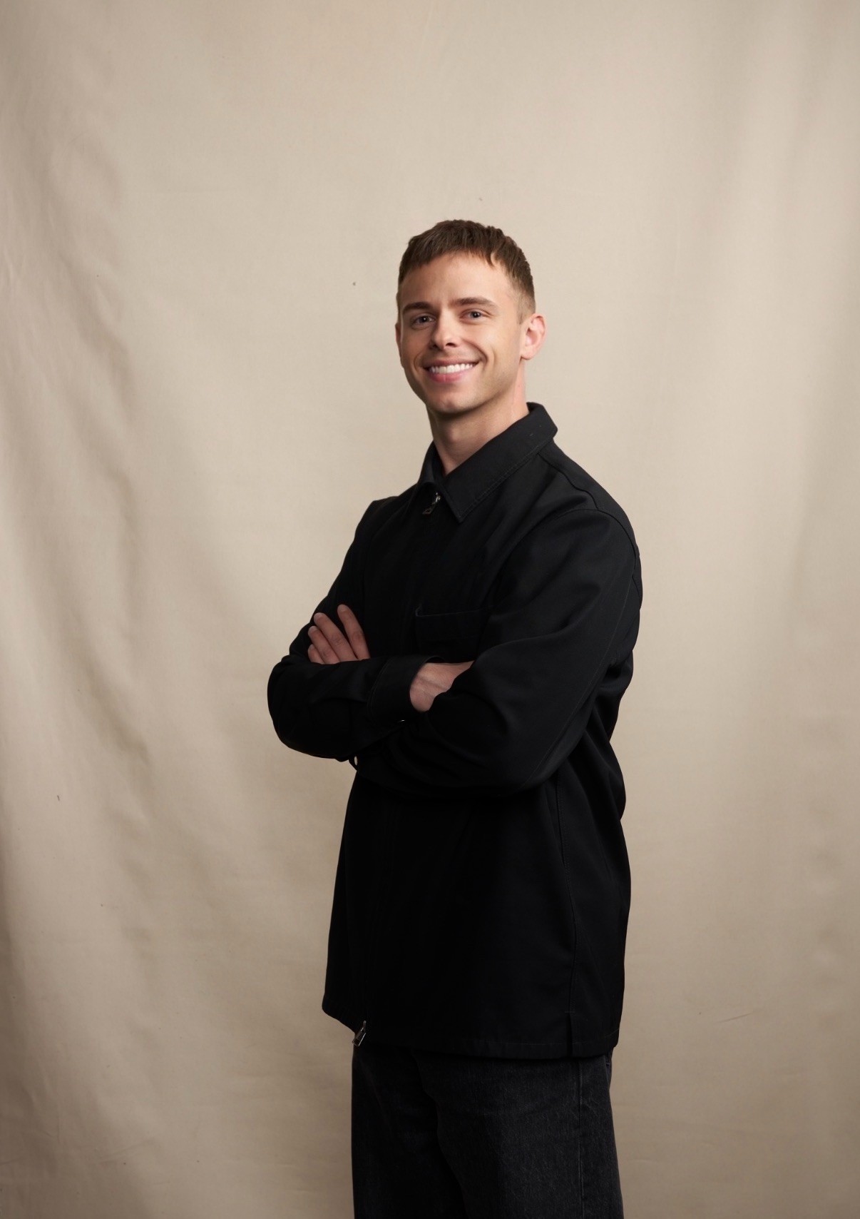 Monochrome product shot: black-capped cosmetic bottle with dynamic water splash on a clean white background.