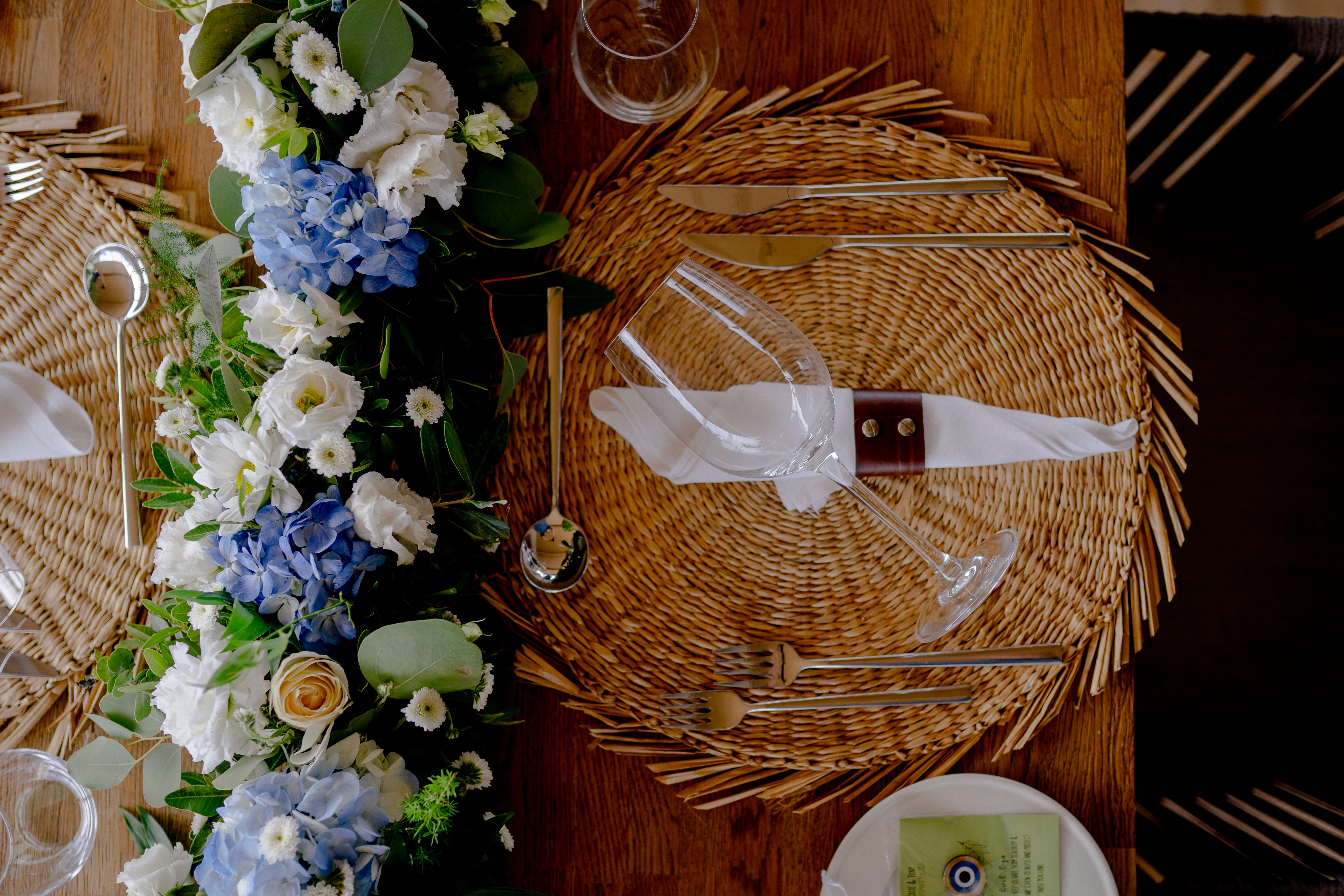 Κομψή γιρλάντα τραπεζιού γάμου με λευκά τριαντάφυλλα, μπλε ορτανσίες και φύλλα ευκαλύπτου