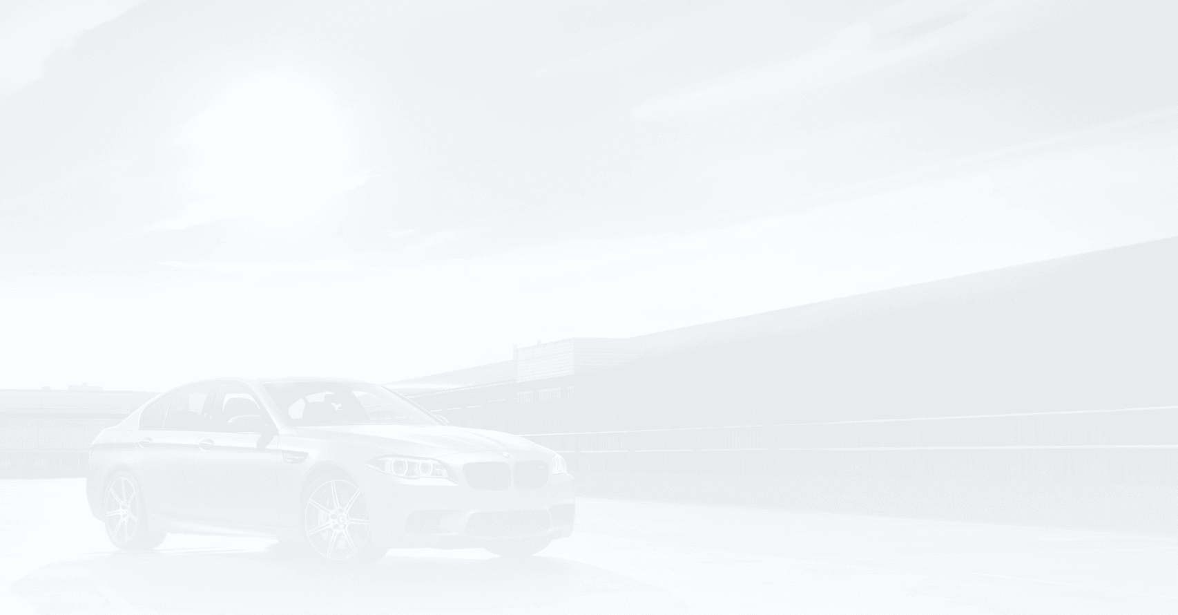Dark grey BMW sedan parked outside a modern industrial building