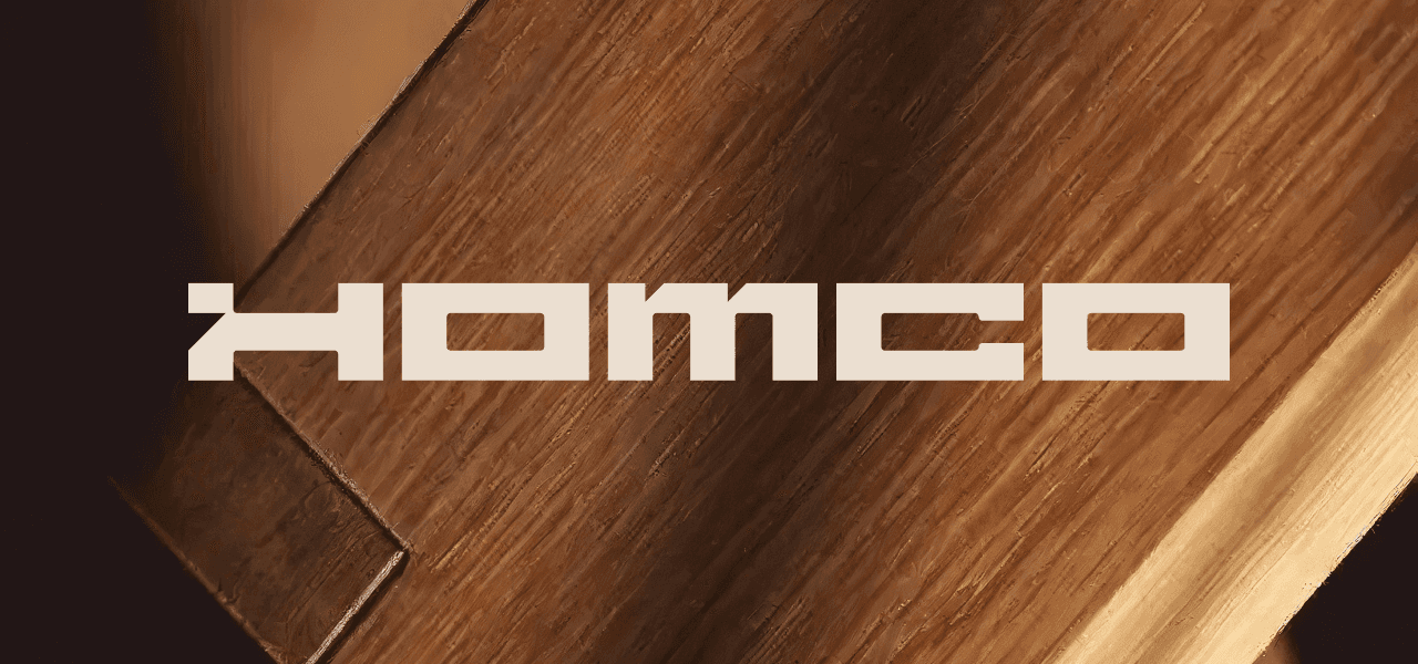 Homco hero — geometric wordmark over wood grain texture, brand identity for Swiss premium construction company