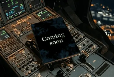 Airplane cockpit control panel at night with a book labeled “Coming soon” placed on the controls.