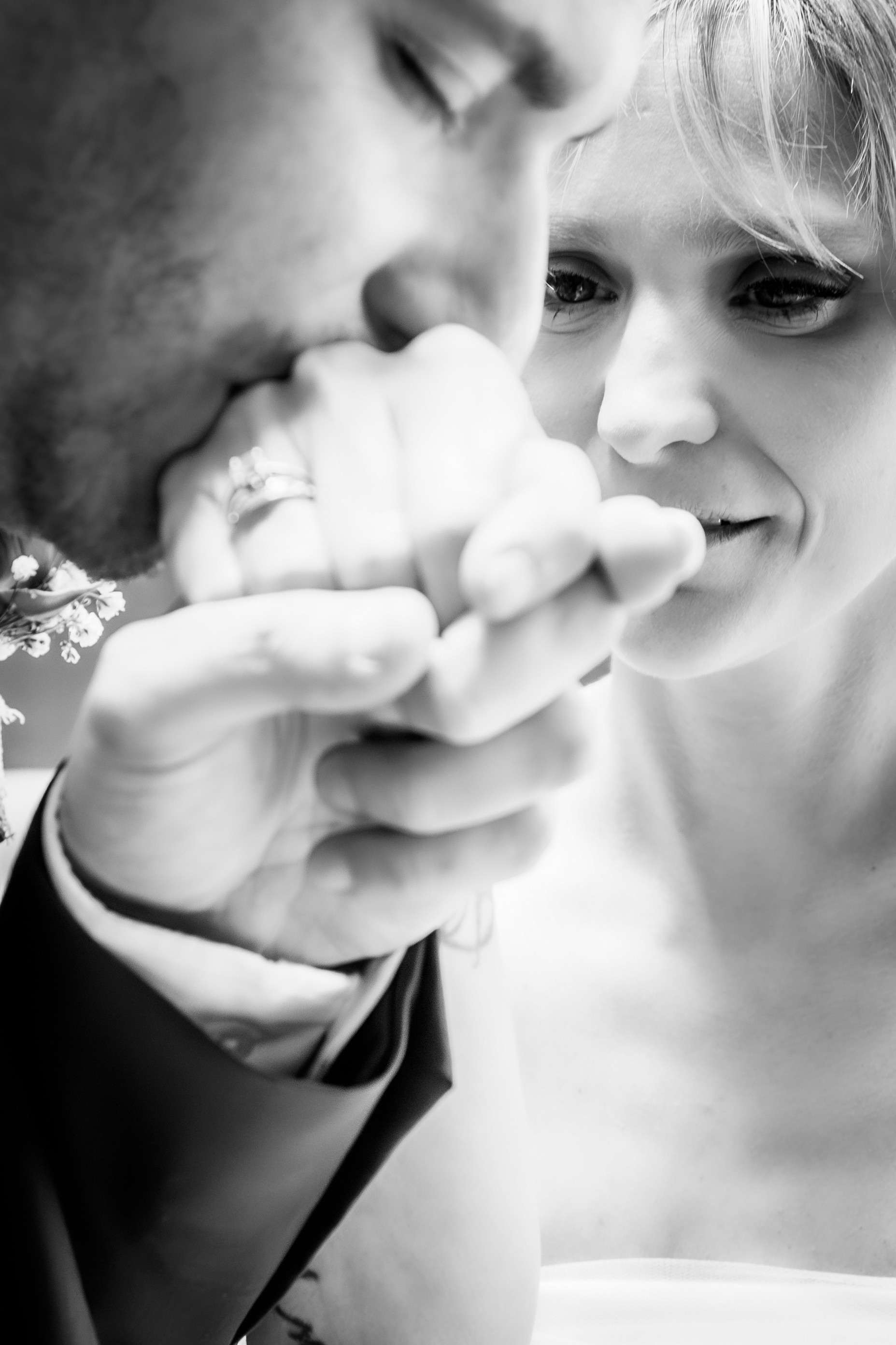 Sesiónde boda en blanco y negro donde el marido le da un beso en la mano a la mujer