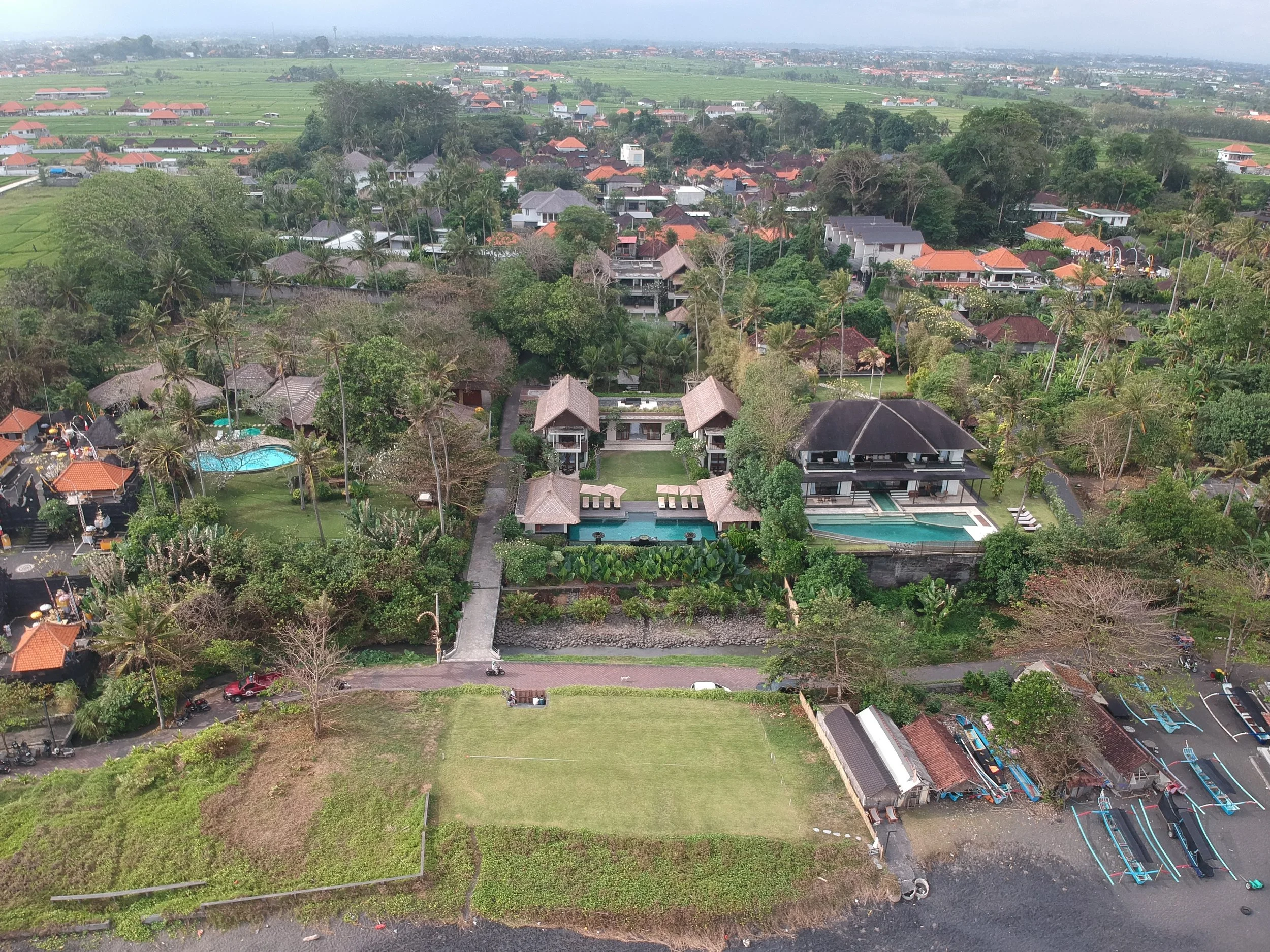 Aerial view of Seseh beach and traditional boats, highlighting prime coastal land for real estate development.