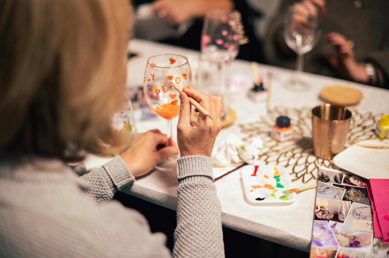 A bride in a white lace wedding dress holds a colorful bouquet of pink, yellow, and orange flowers.