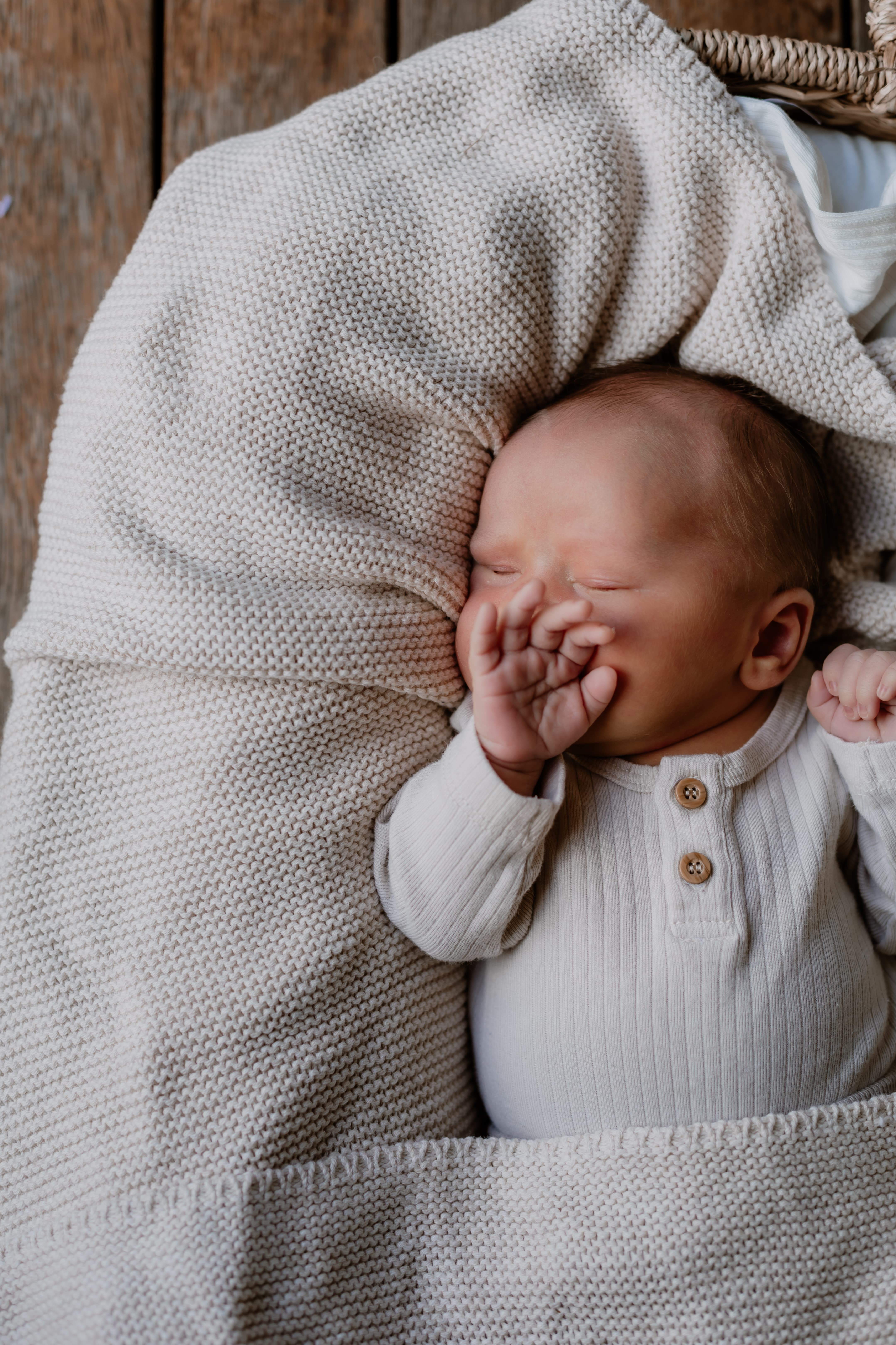 Newborn baby covering it's face with their hand while asleep, Newborn Photography Mackay
