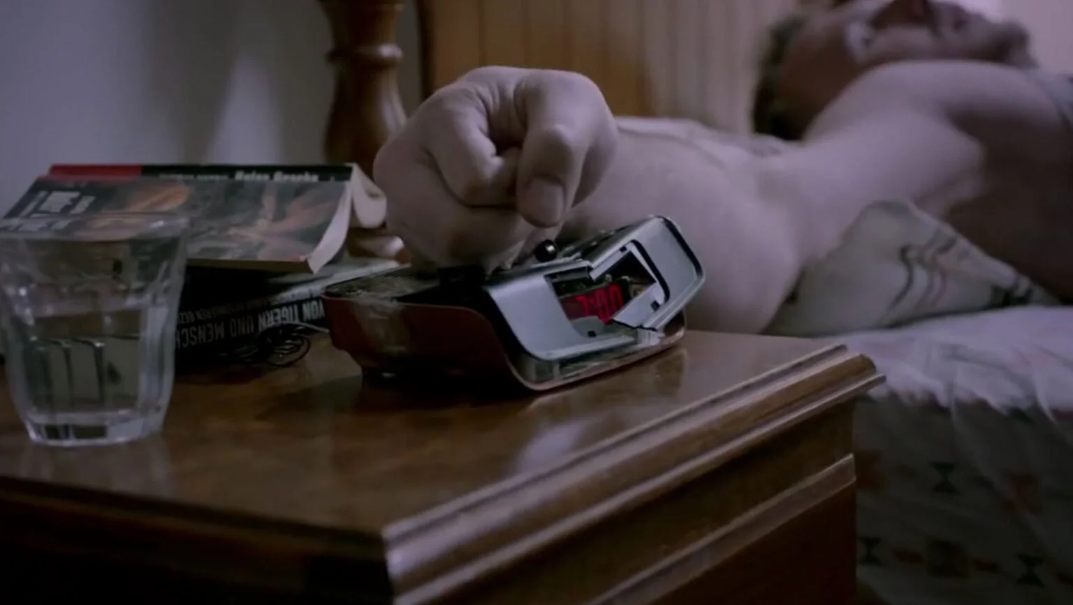 Man in bed thumping an alarm clock on a bedside table, still from the AEG 'Unexpected Power' film