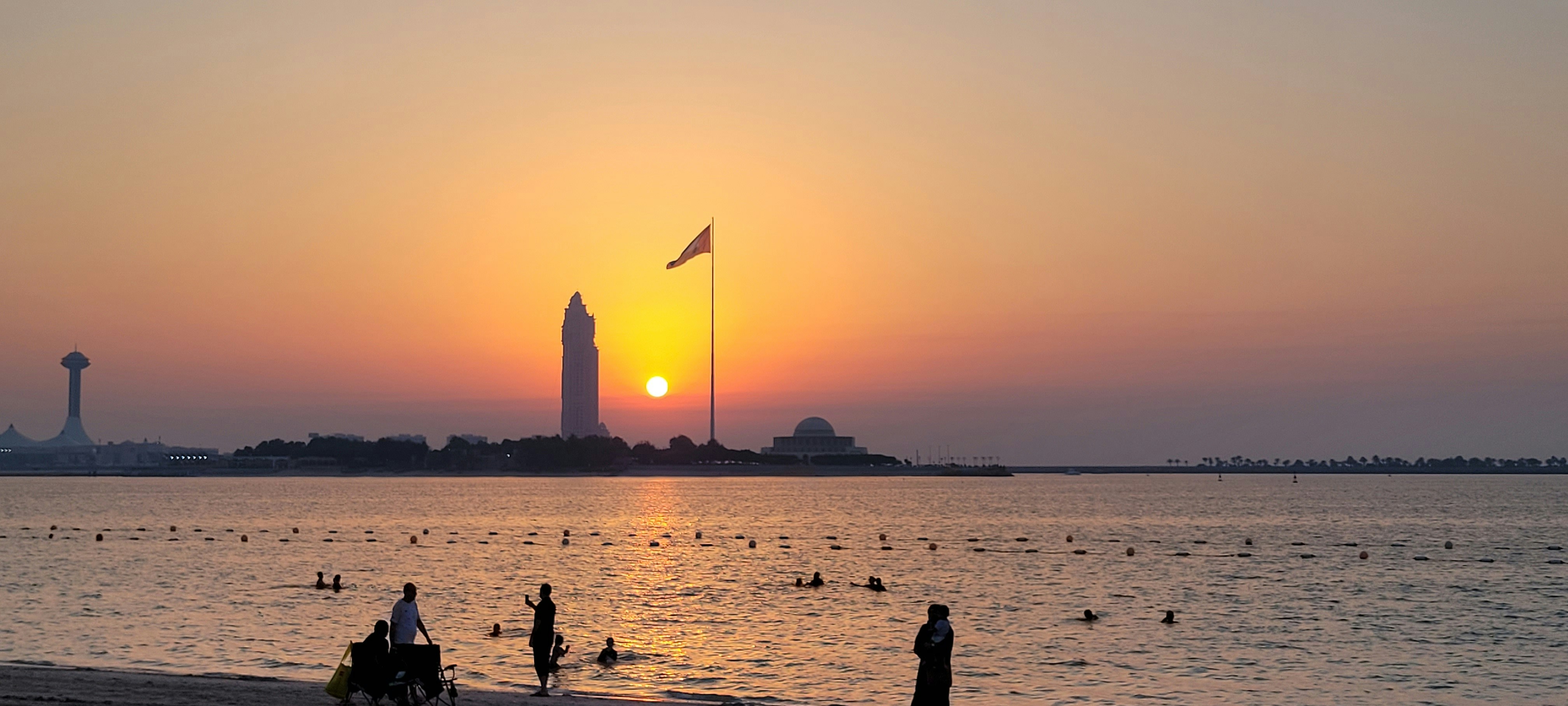 the sun is setting over the water at the beach