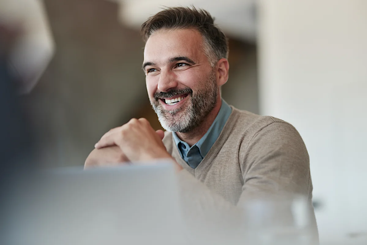 Smiling legal professional in conversation during a meeting, representing collaboration and confidence in a modern legal environment.