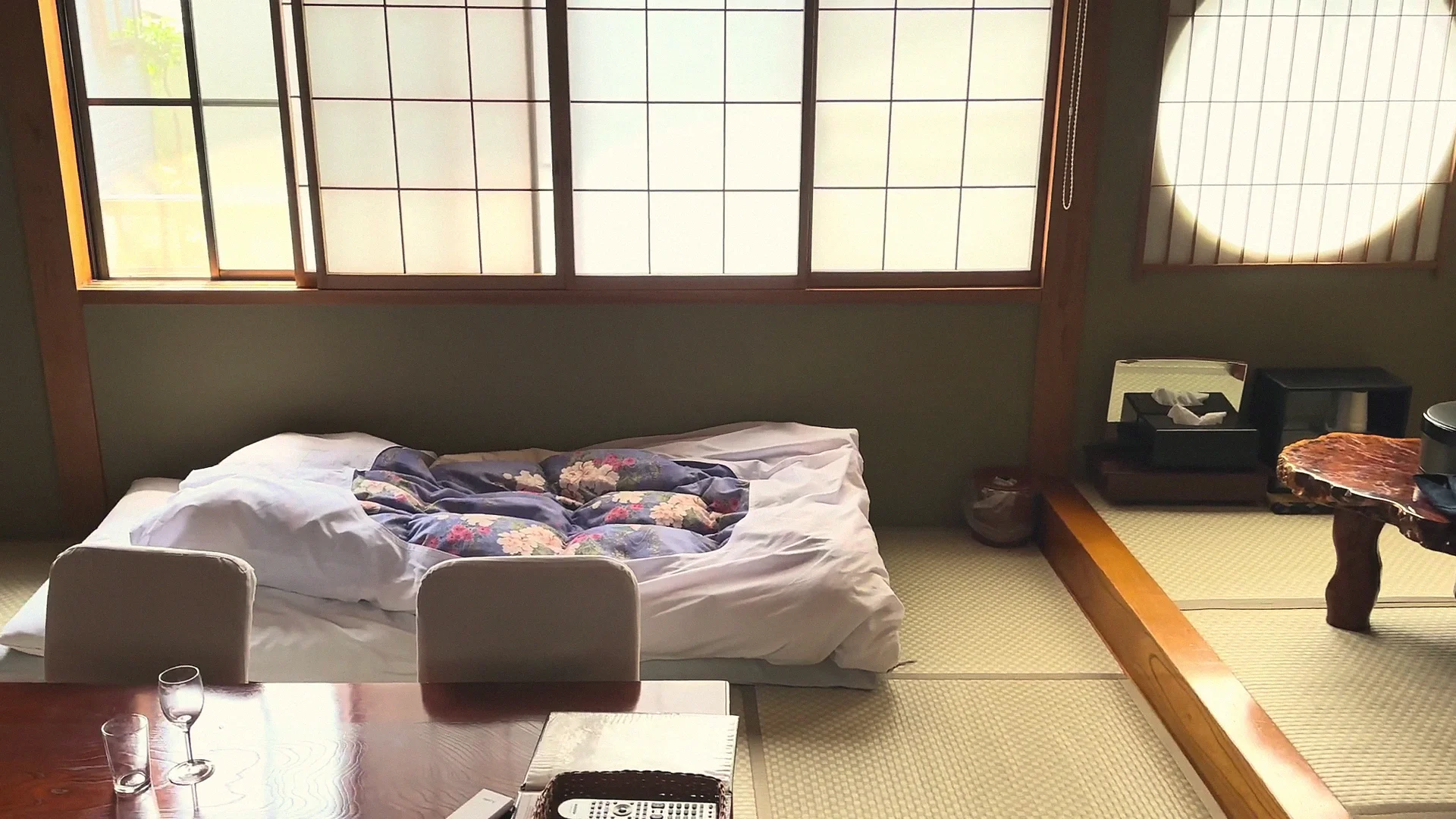 Tatami ryokan room with futon laid out and a low table