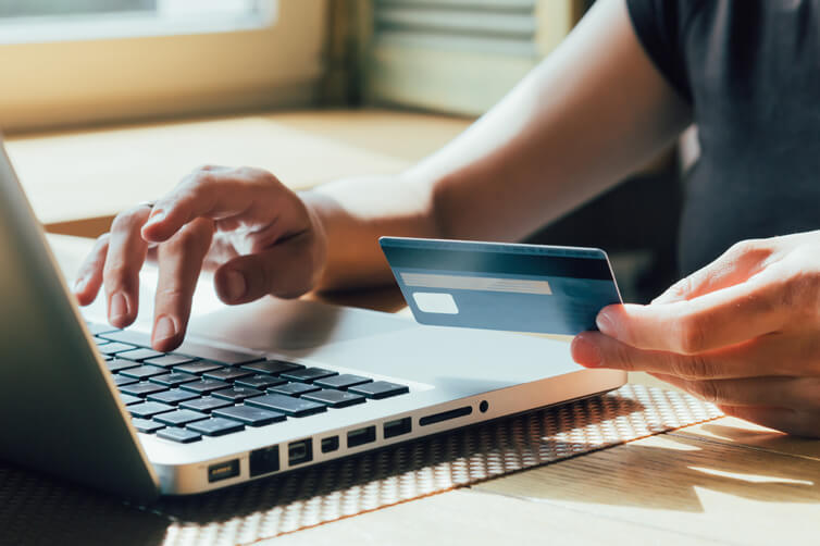Person making online payment with credit card and laptop