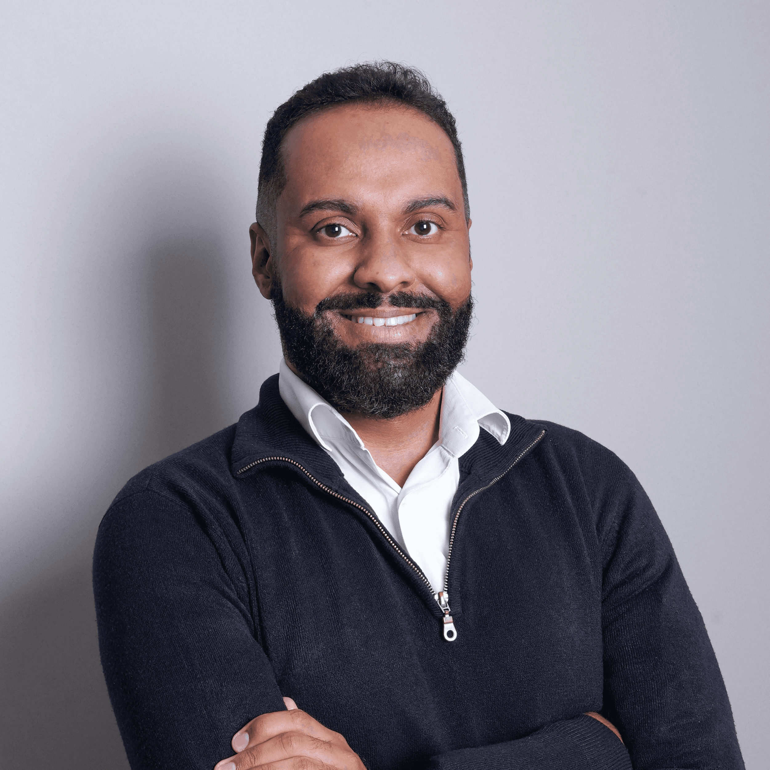 an executive leader smiling with his arms crossed