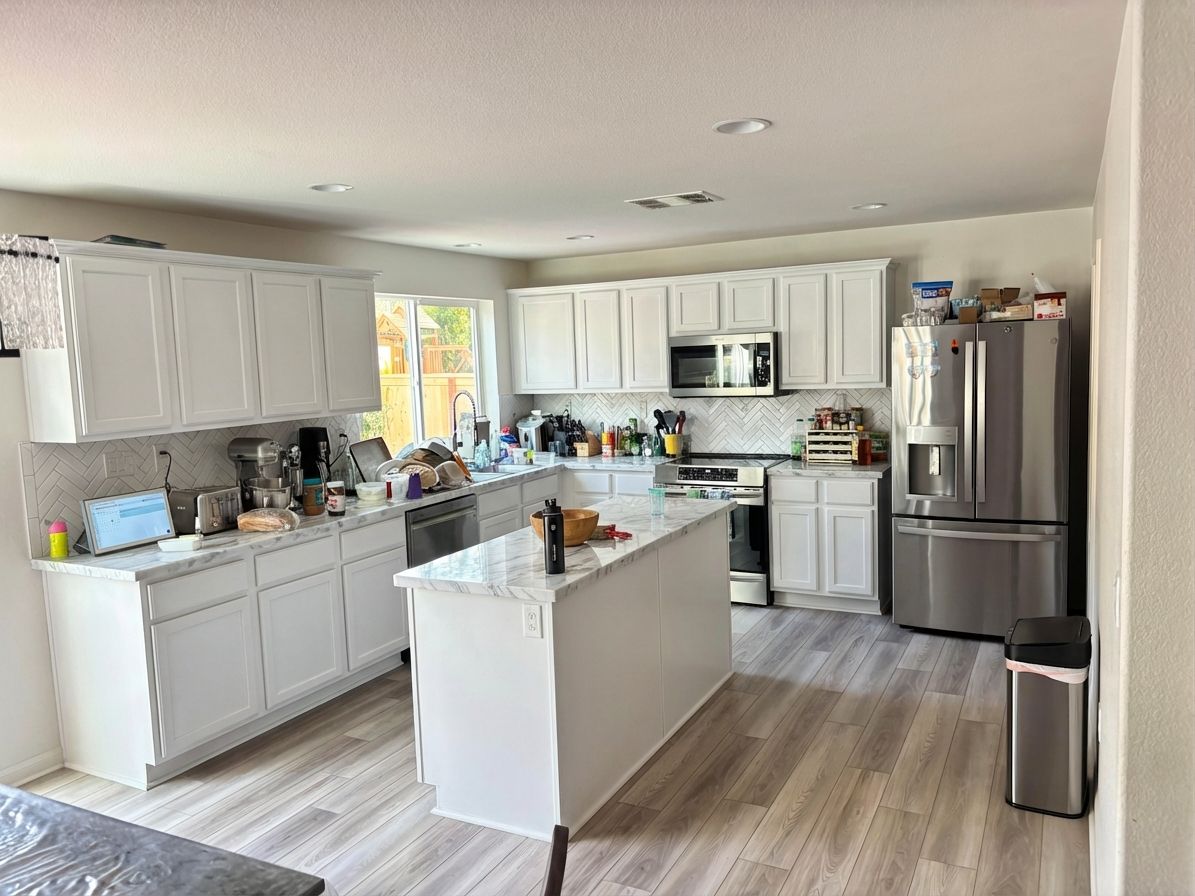 Kitchen remodeled with white cabinets and marble countertops using AI