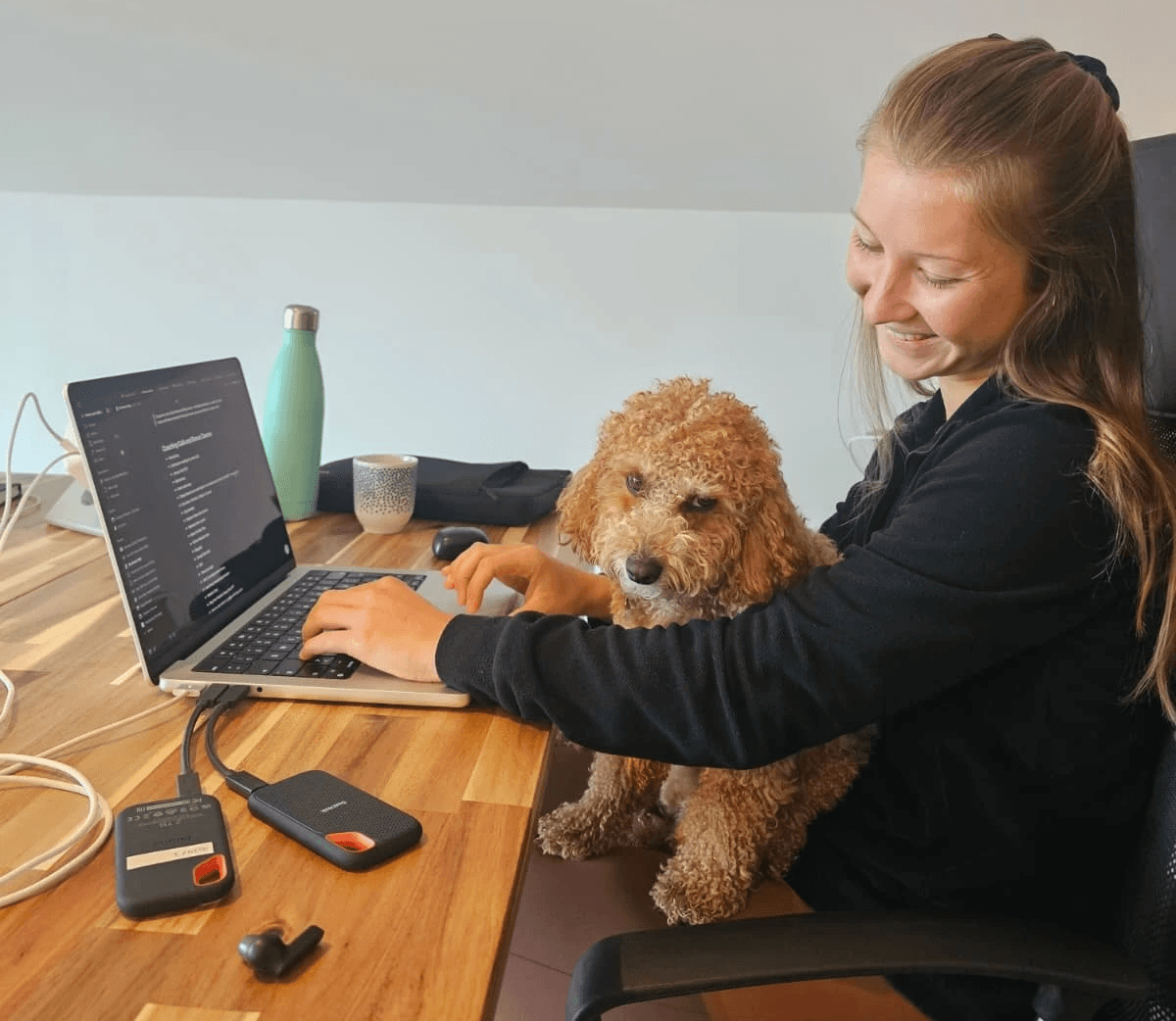 Young woman coworking at Wild Souls Coliving with a dog in her lap