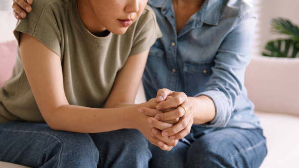 two people holding hands comforting