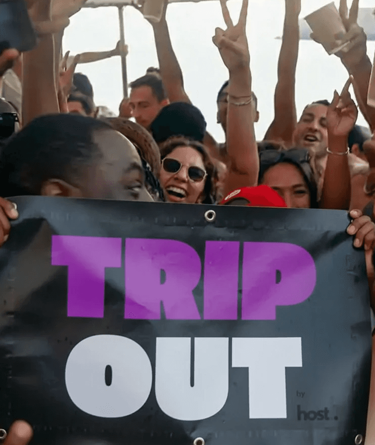 Four hands clinking beer glasses over table of food