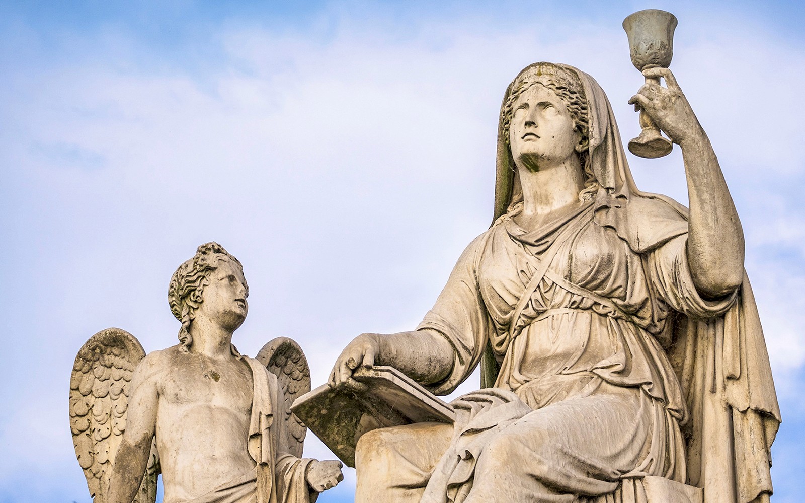 Statues of an angel and a woman with a chalice on the Torino Magica tour.
