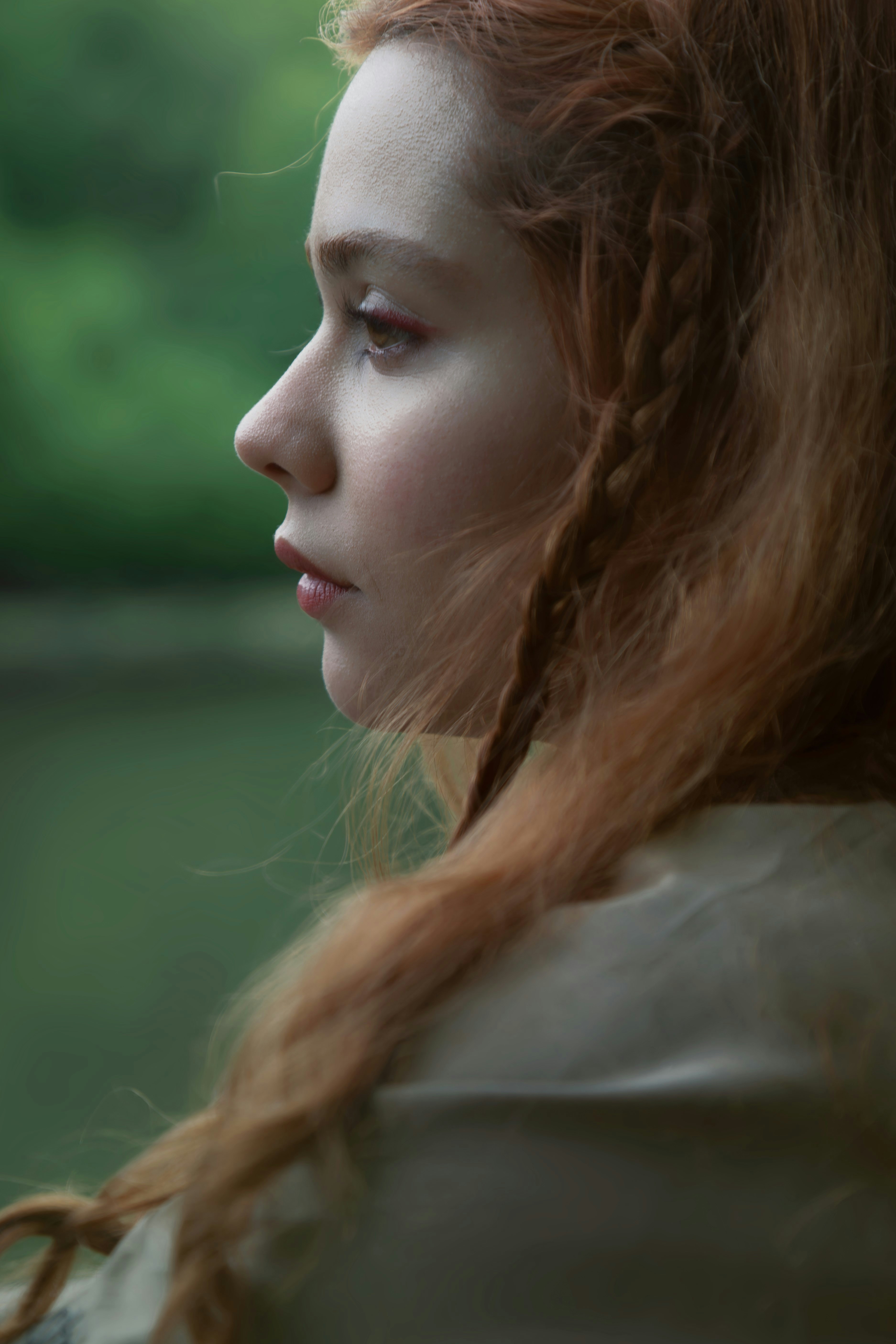 a woman with long red hair and braids on her head