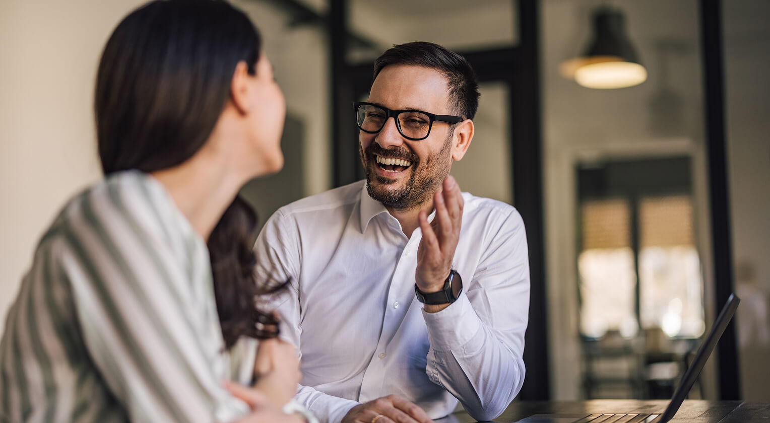 Two individuals having a friendly conversation in a professional setting