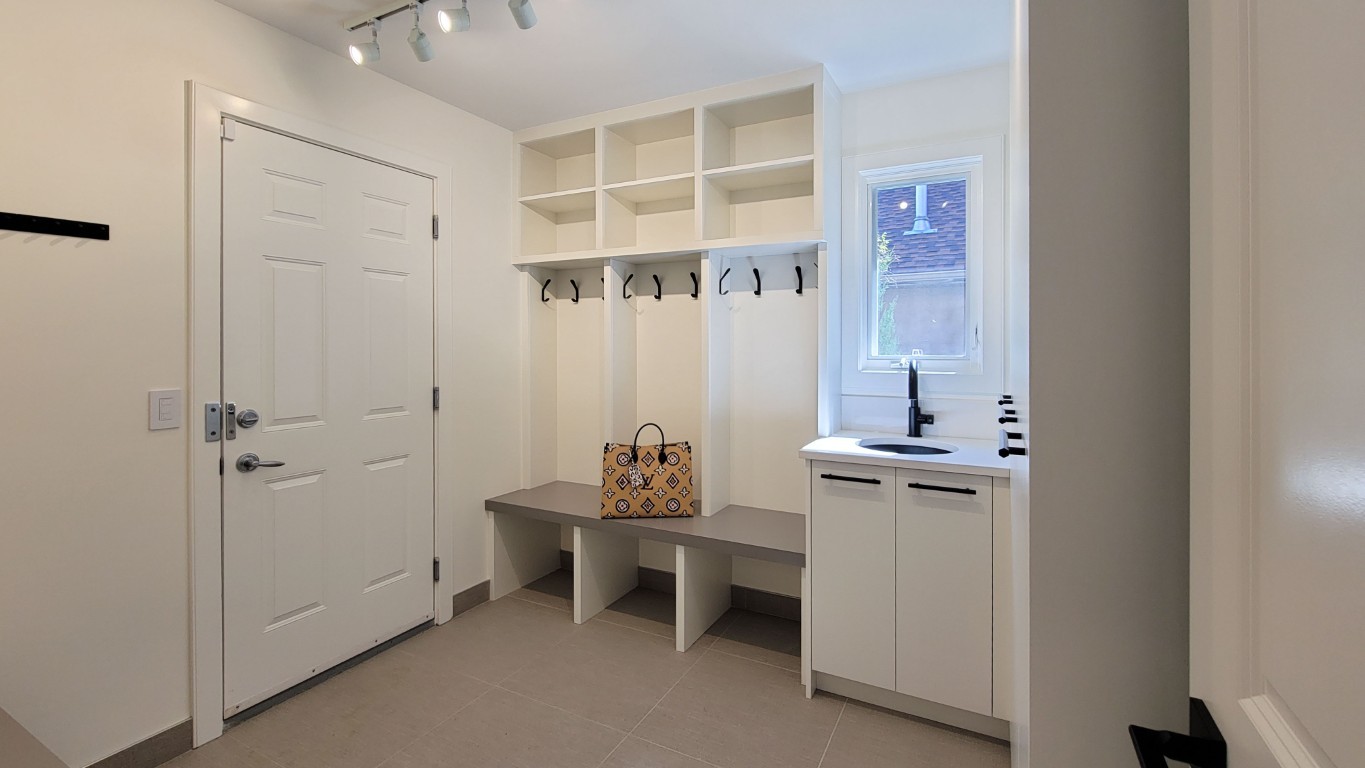 Image of Mudroom with built-in storage, seating, and sink by KHD Homes, showcasing design and construction expertise.