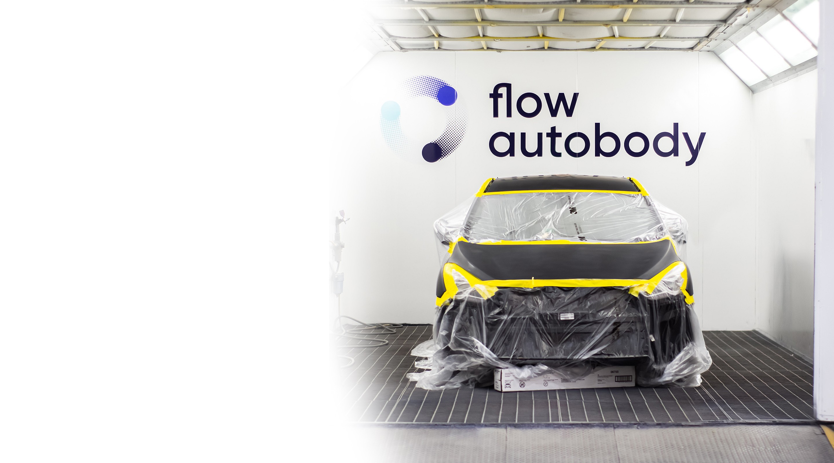 Car covered in plastic in a paint booth