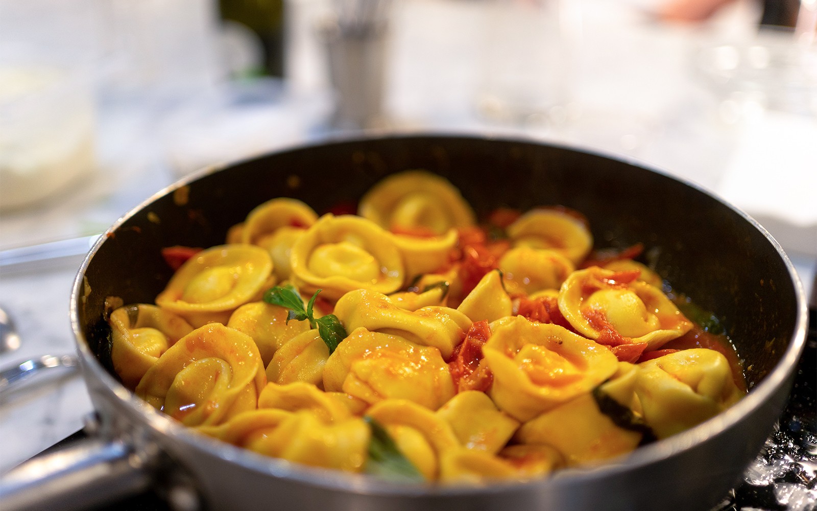 Tortellini cooking in a pan during a pasta class in Milan.