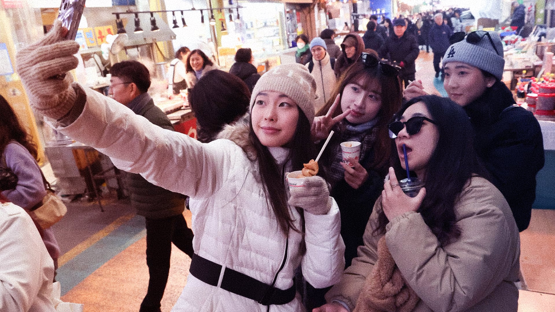 Nhóm du khách nước ngoài trẻ tuổi chụp selfie trong chợ hải sản Noryangjin Seoul mùa đông