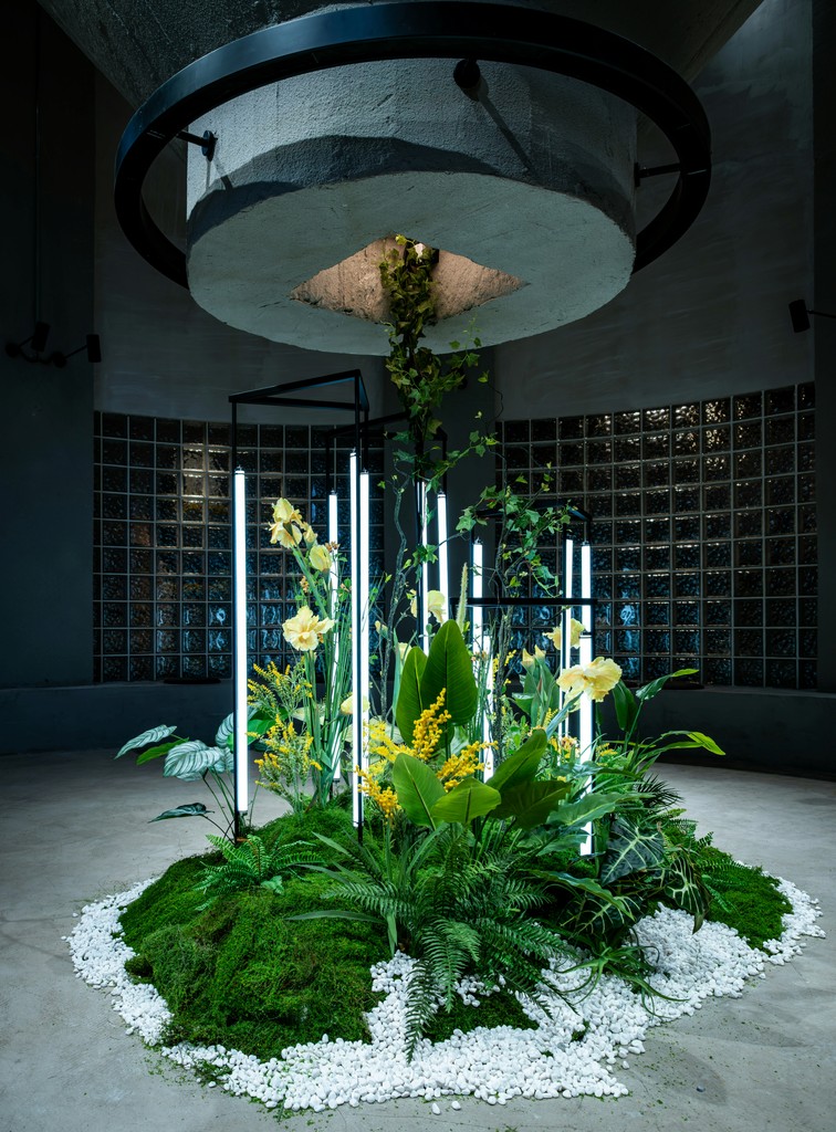 Indoor garden installation with yellow flowers and lights