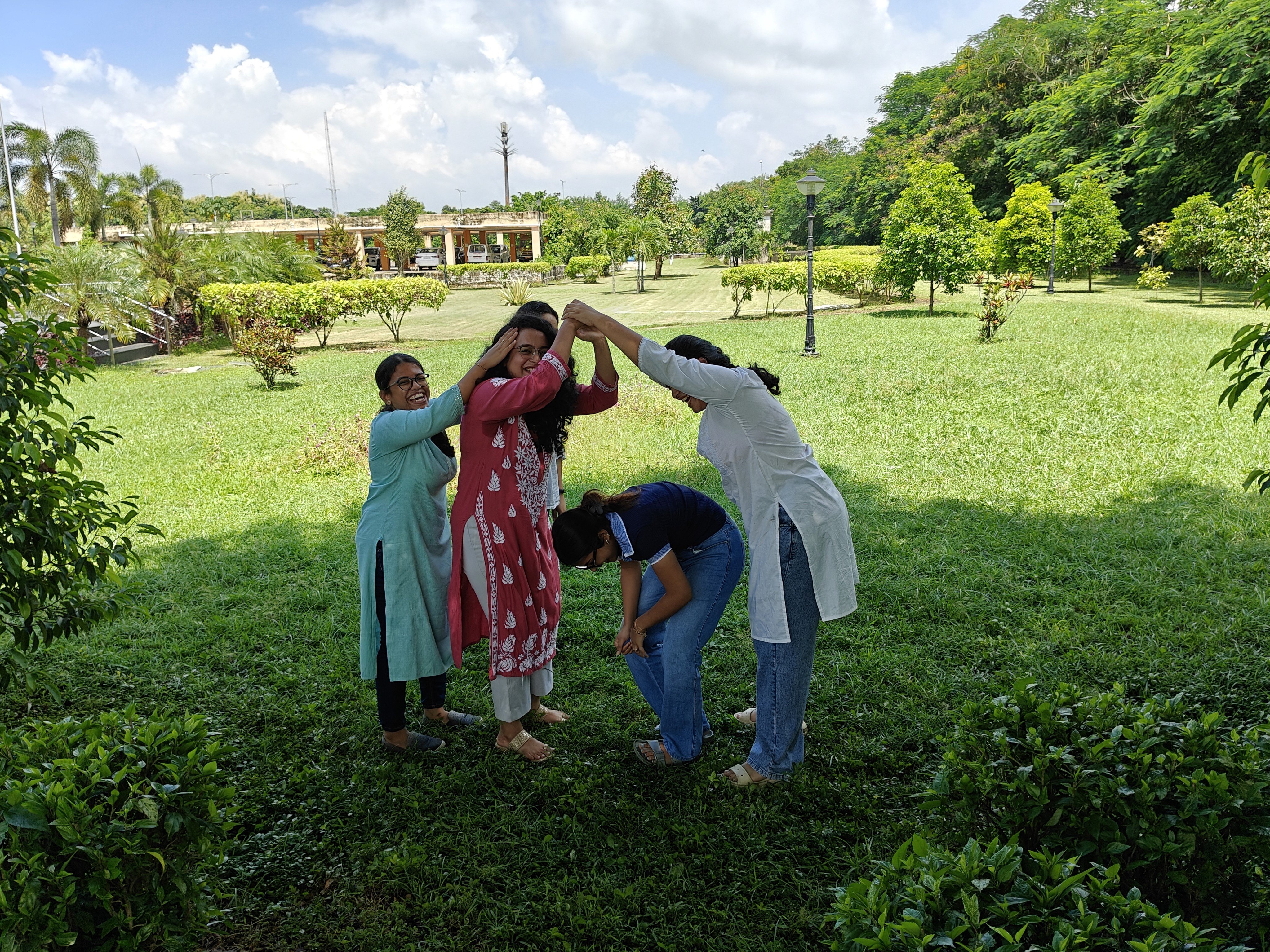 Students holding hands together to form a tree