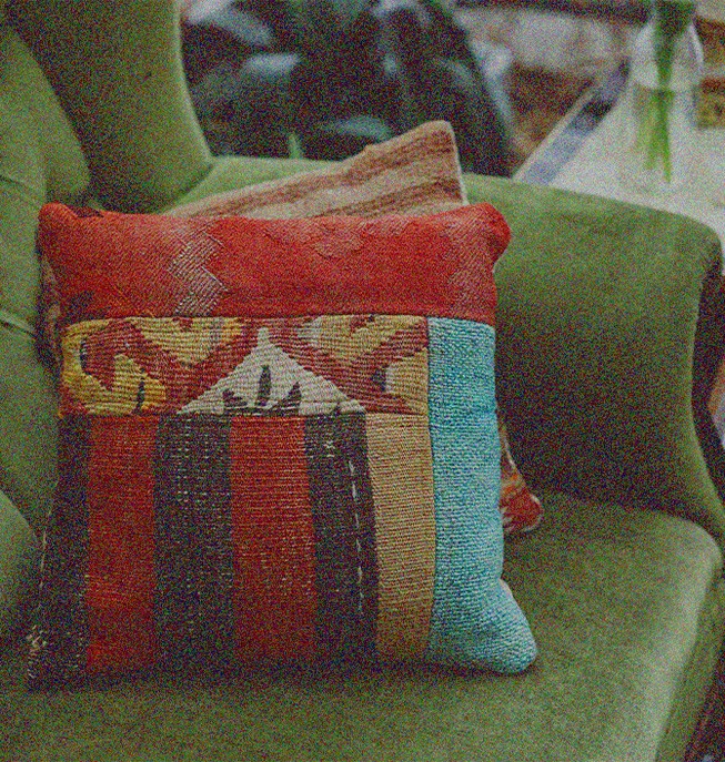 Green armchair with multi-colored throw pillows in therapy office