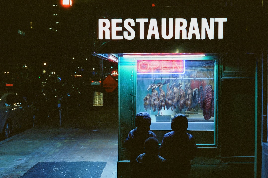 People admire the food display in a restaurant window.