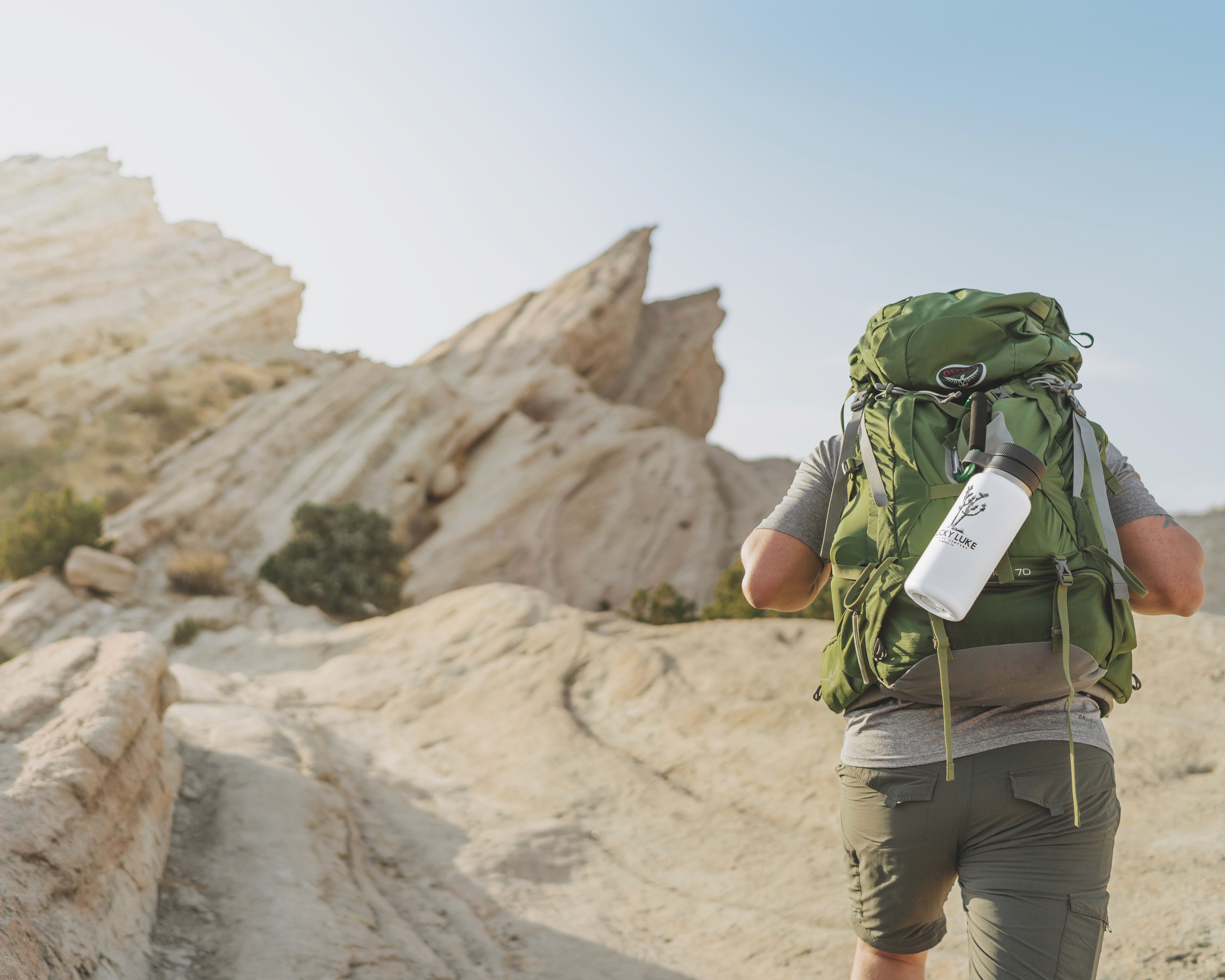 Hiker carrying Lucky Luke branded can on backpack
