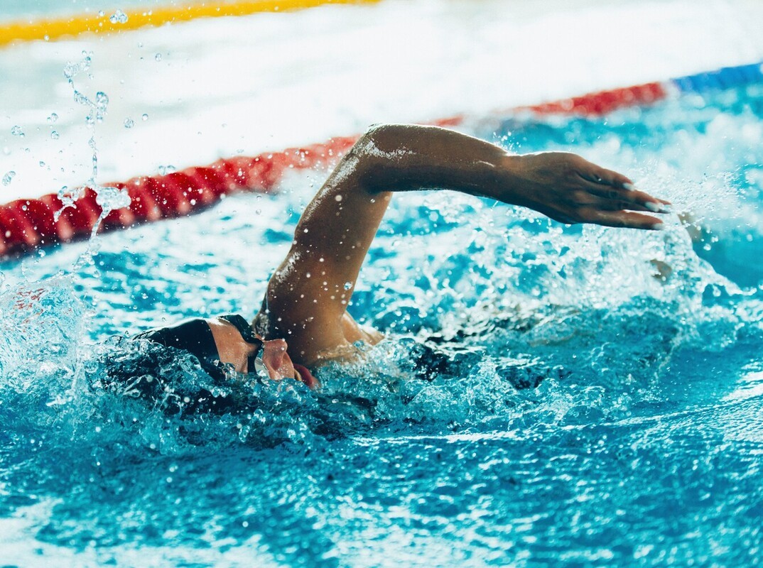 woman doing high-intensity swimming exercises to lose weight at the gym