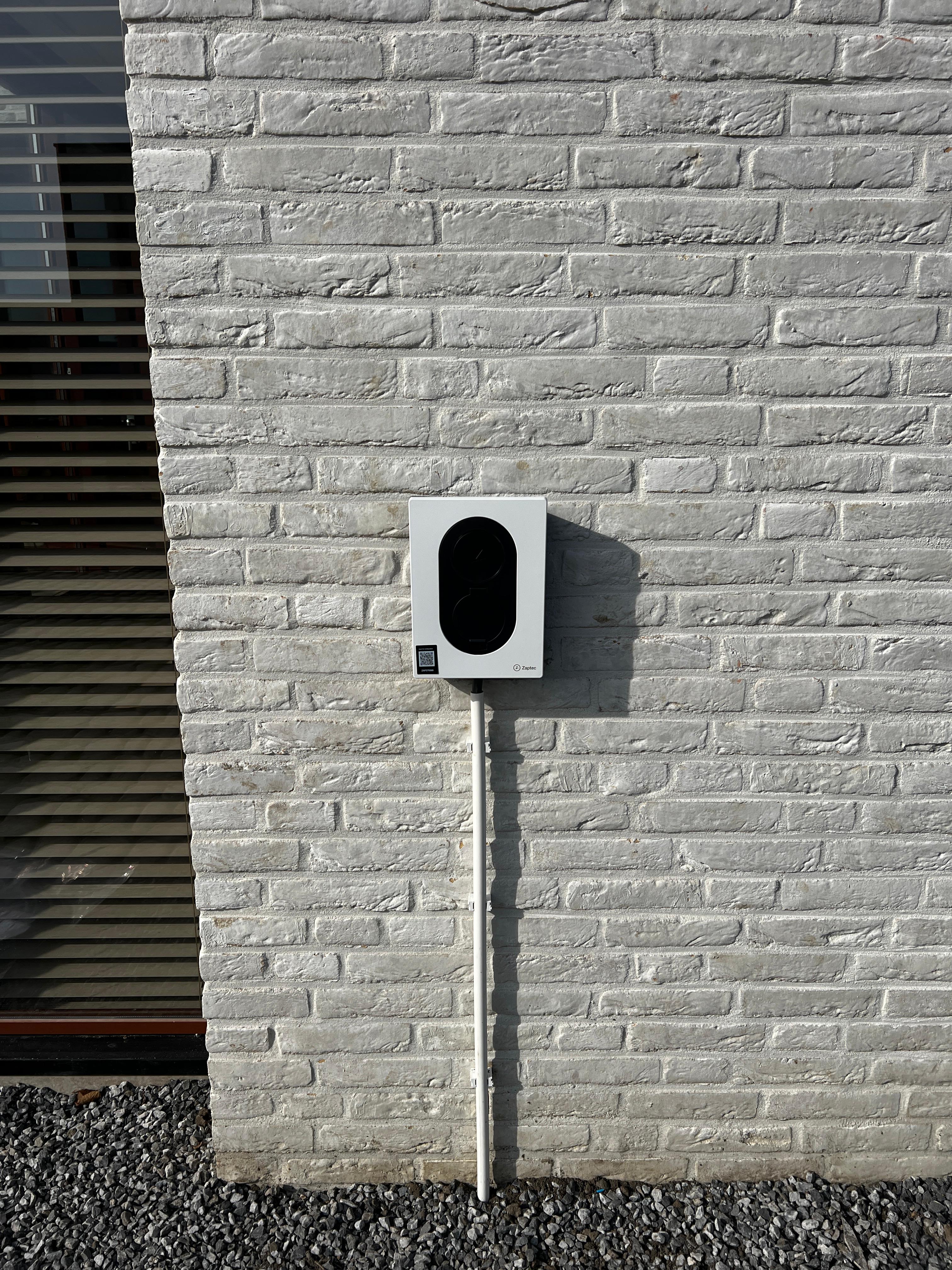 Modern glass building with illuminated facade and trees at sunset