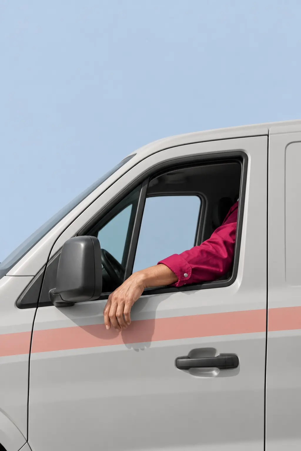 Technician's arm resting on the open window of a grey service van