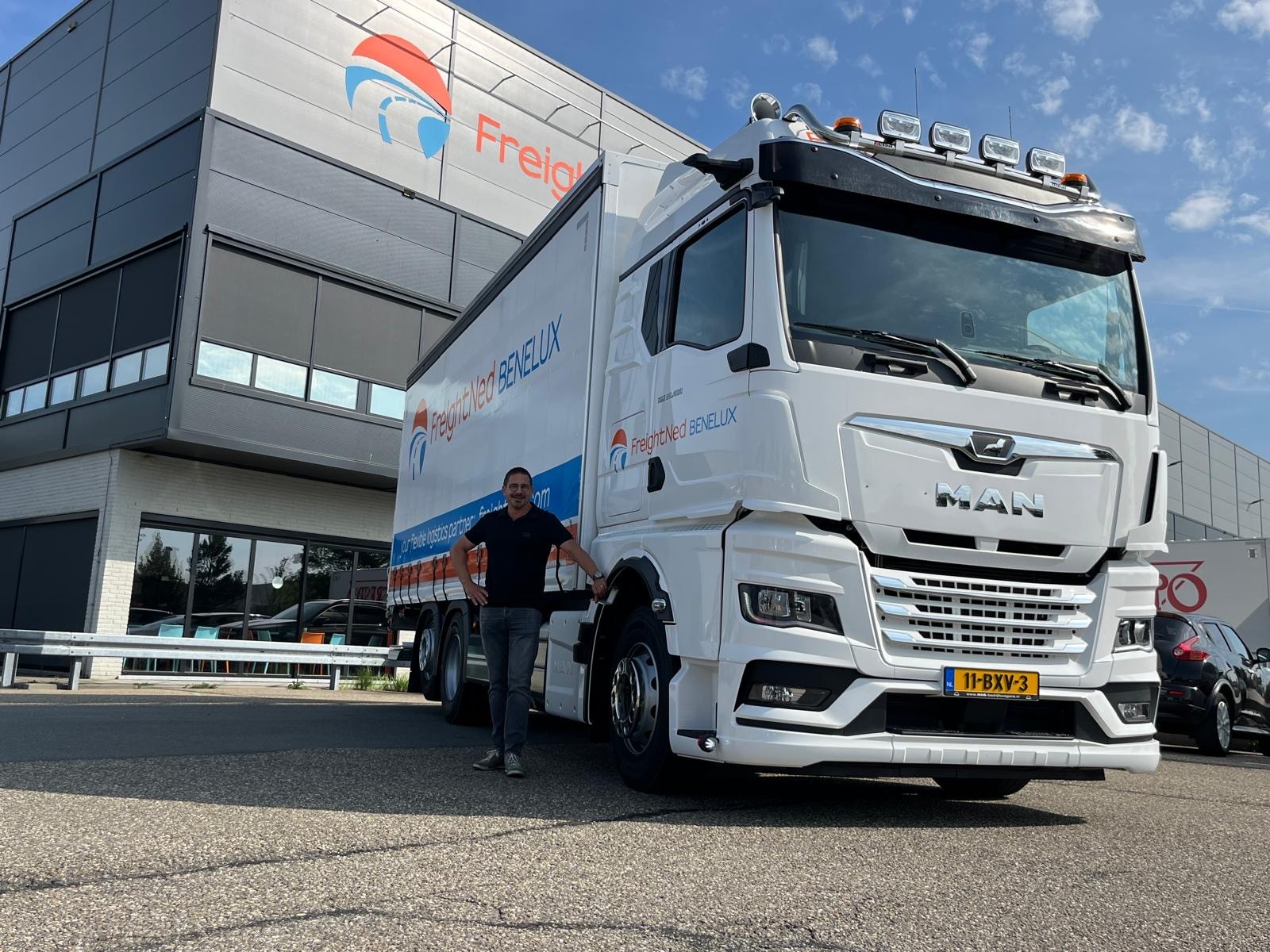 man die voor zijn vrachtwagen staat