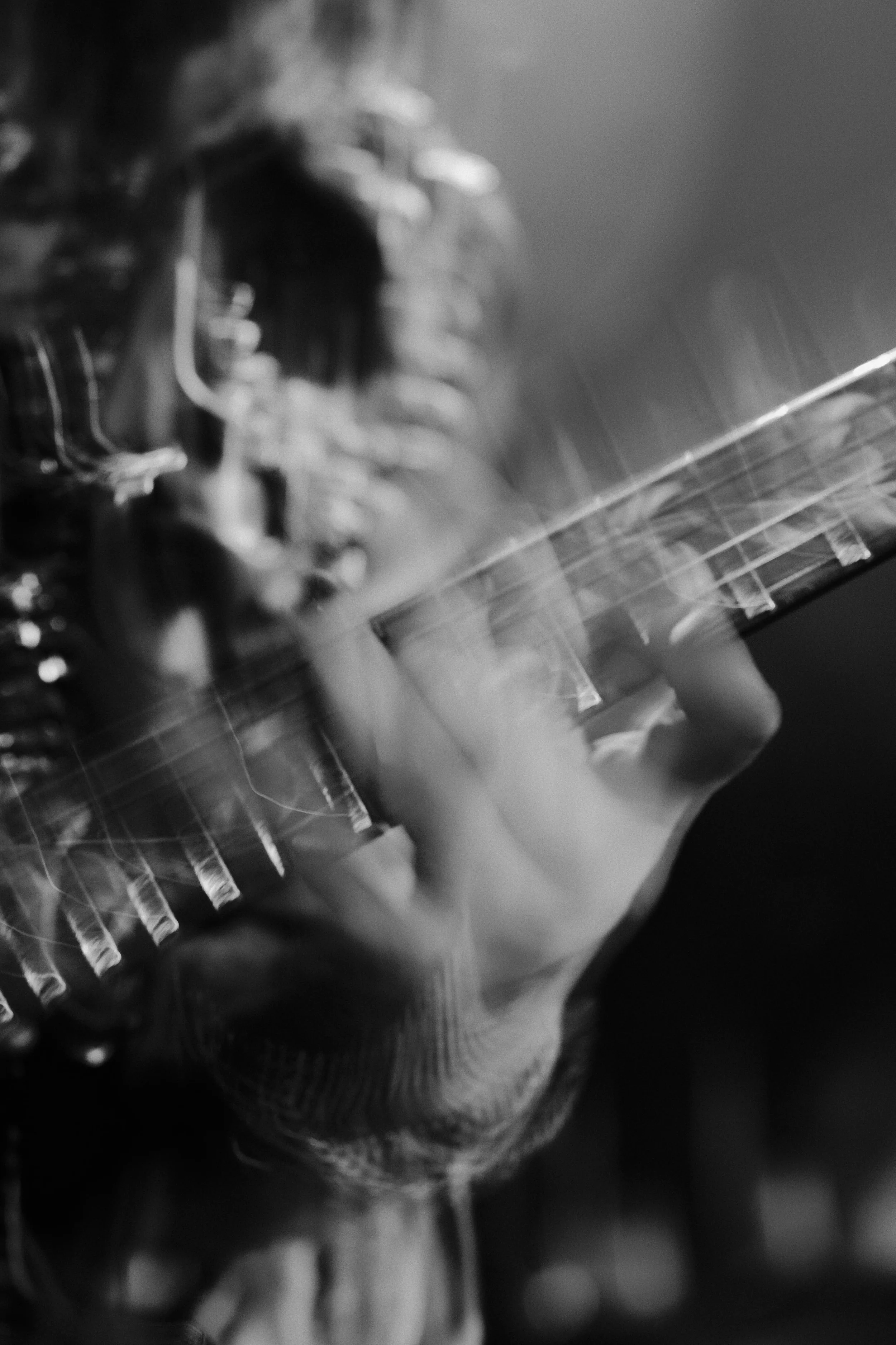Photographie de concert en noir et blanc, volontairement floue, capturant le mouvement et l'énergie de l'artiste
